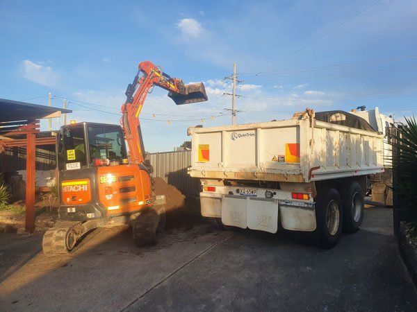 Orange excavator and tippper truck