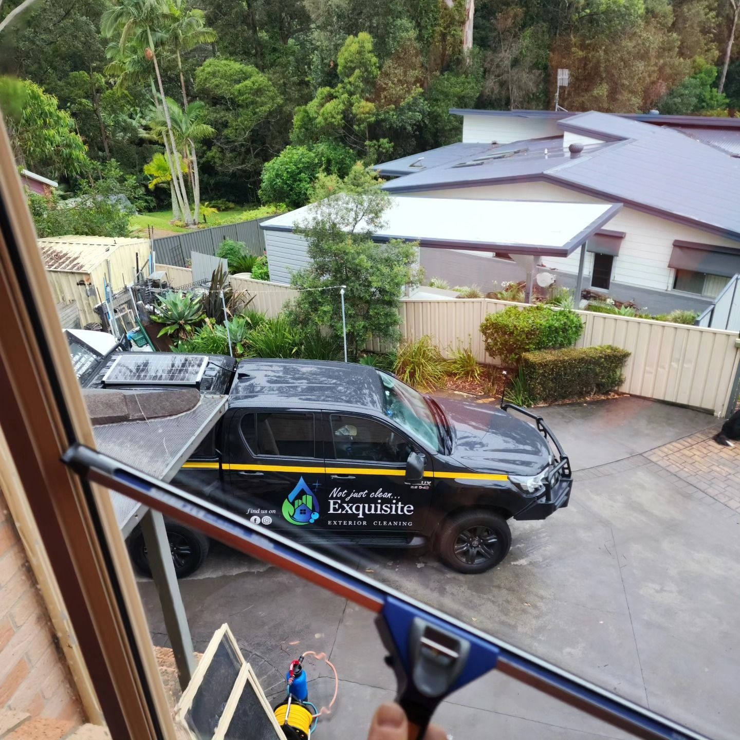 View From a Window Being Cleaned With a Squeegee — Exquisite Exterior Cleaning in North Gosford, NSW