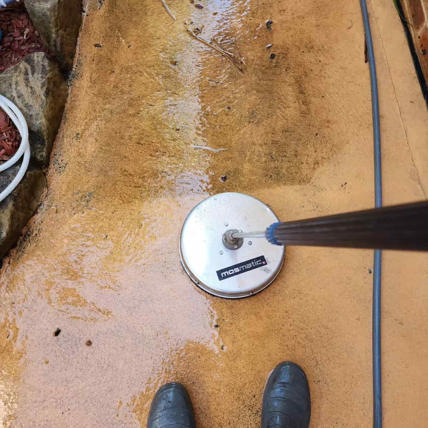 A Person Using a Surface Cleaner on a Concrete Patio — Exquisite Exterior Cleaning In Terrigal, NSW