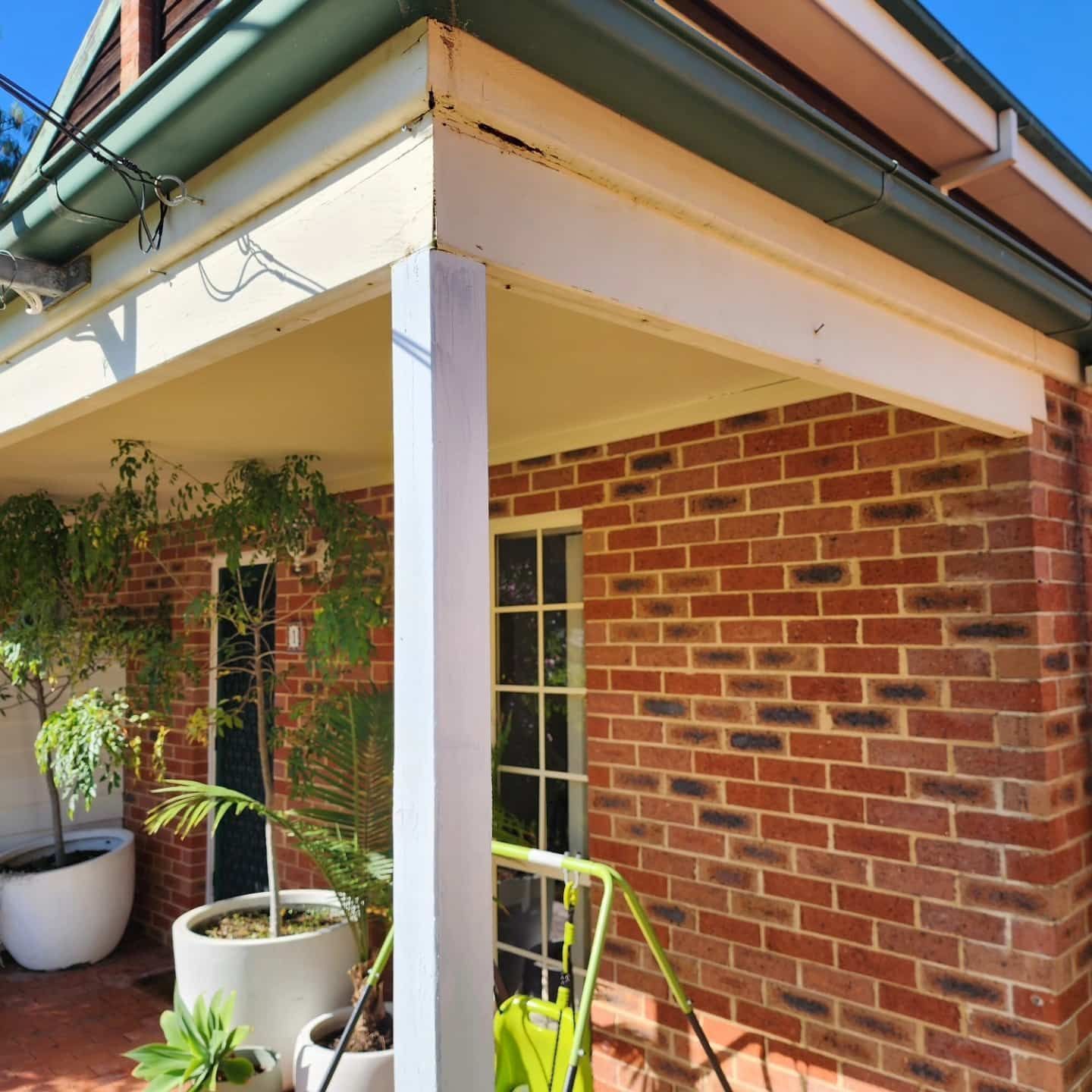 A Brick House With Potted Plants — Exquisite Exterior Cleaning In Central Coast, NSW