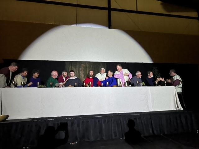 A group of people standing around a long table