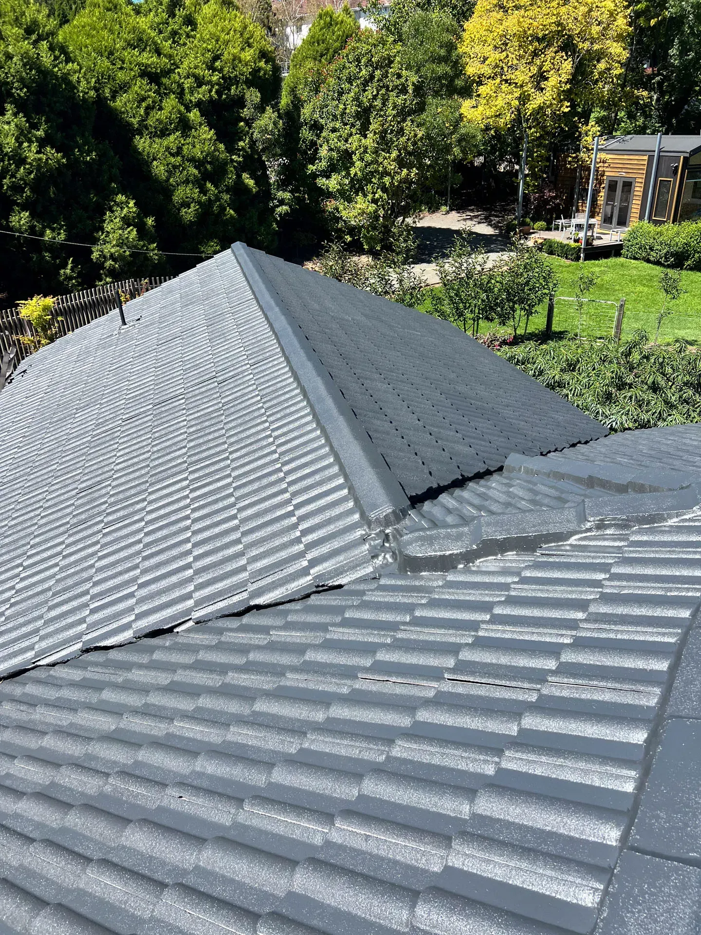 A close up of a roof with trees in the background.