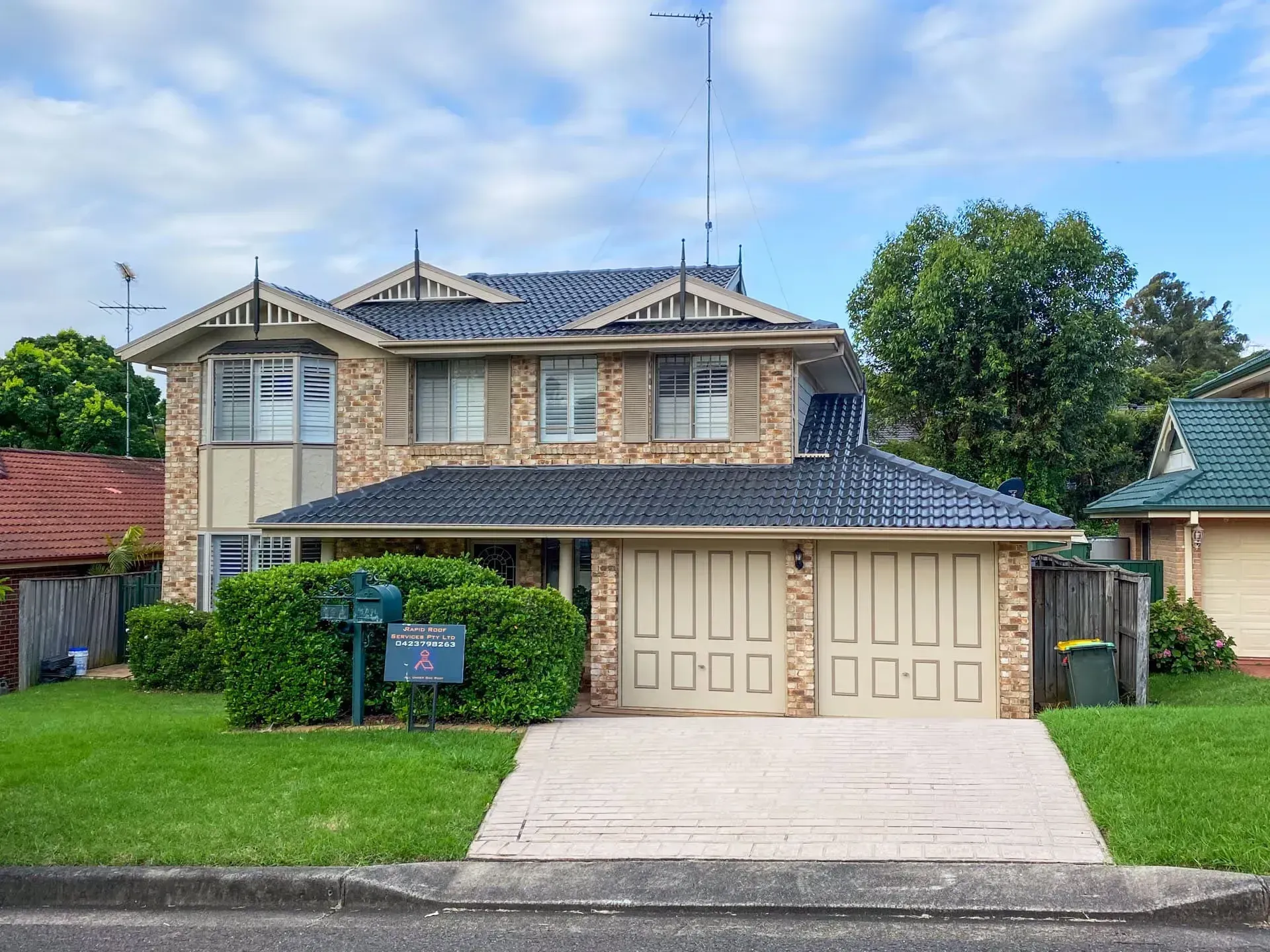 A large brick house with a blue roof is for sale