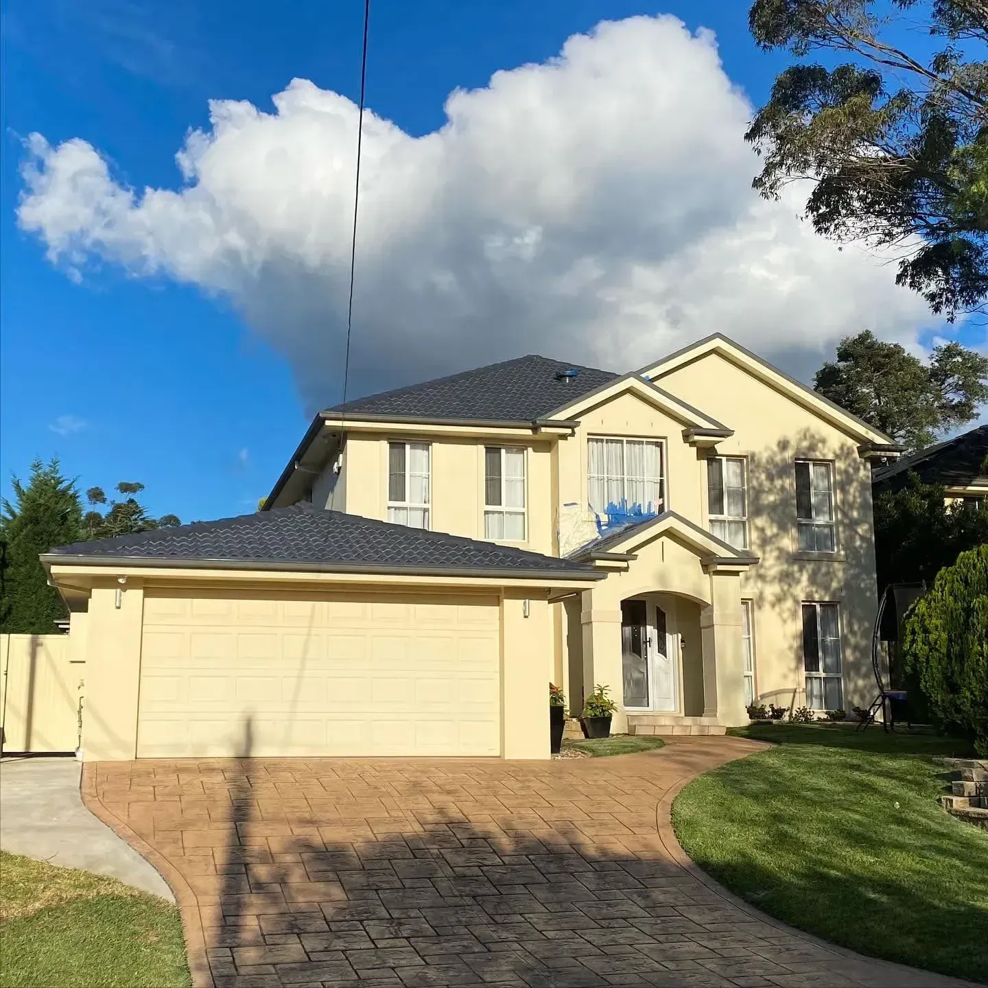 A large house with a brick driveway leading to it