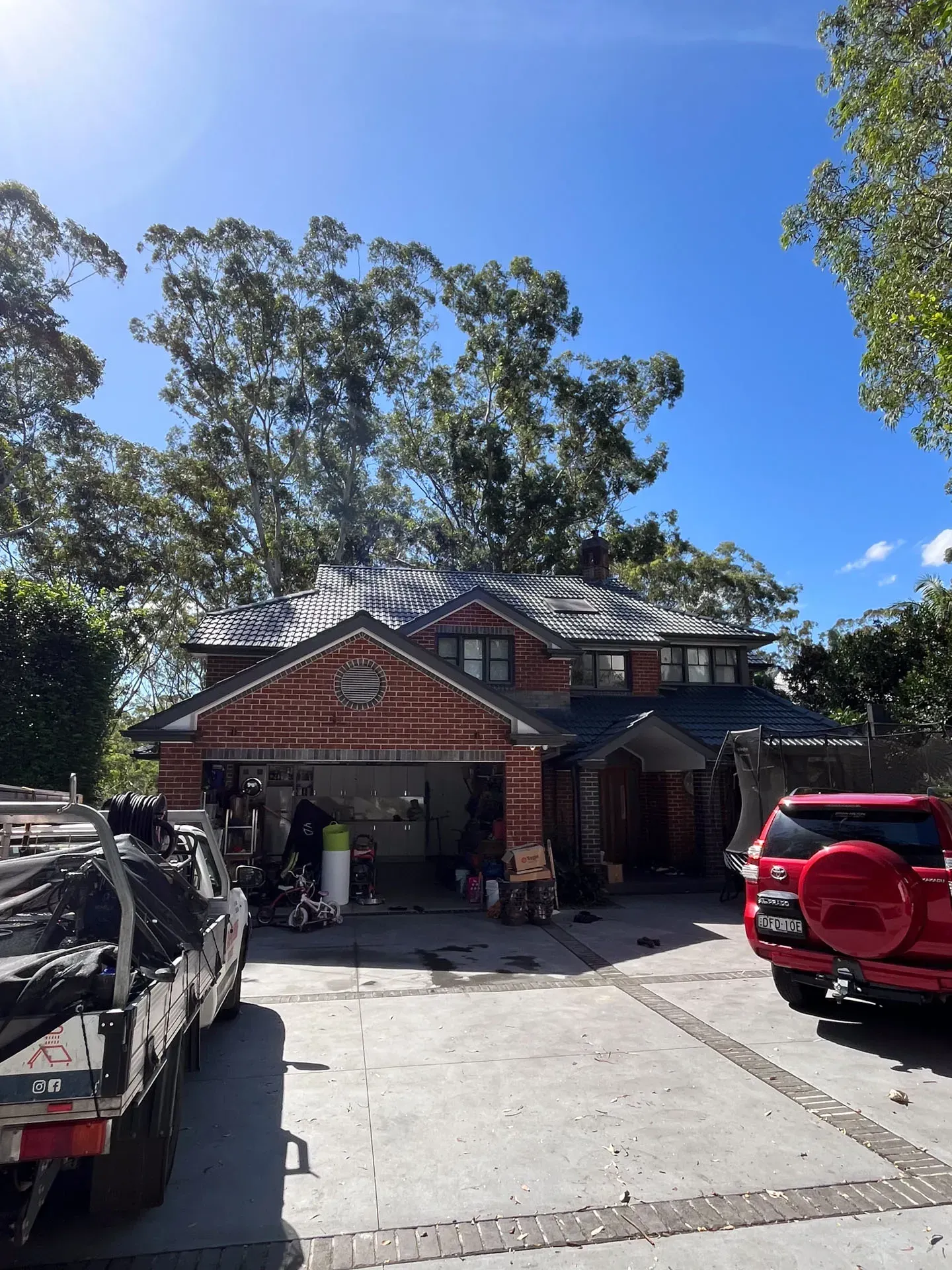 A red truck is parked in front of a large house.