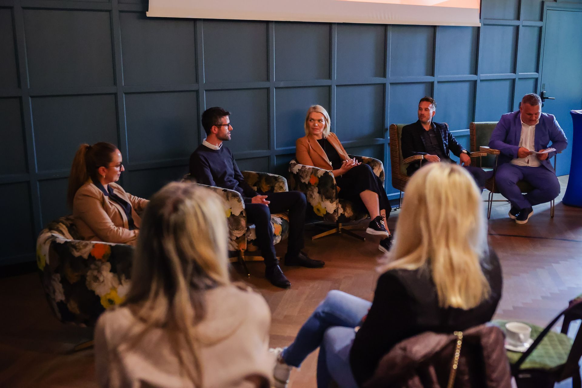 Udeleženci okrogle mize razpravljajo o uporabi umetne inteligence in njenem vplivu na poslovanje.