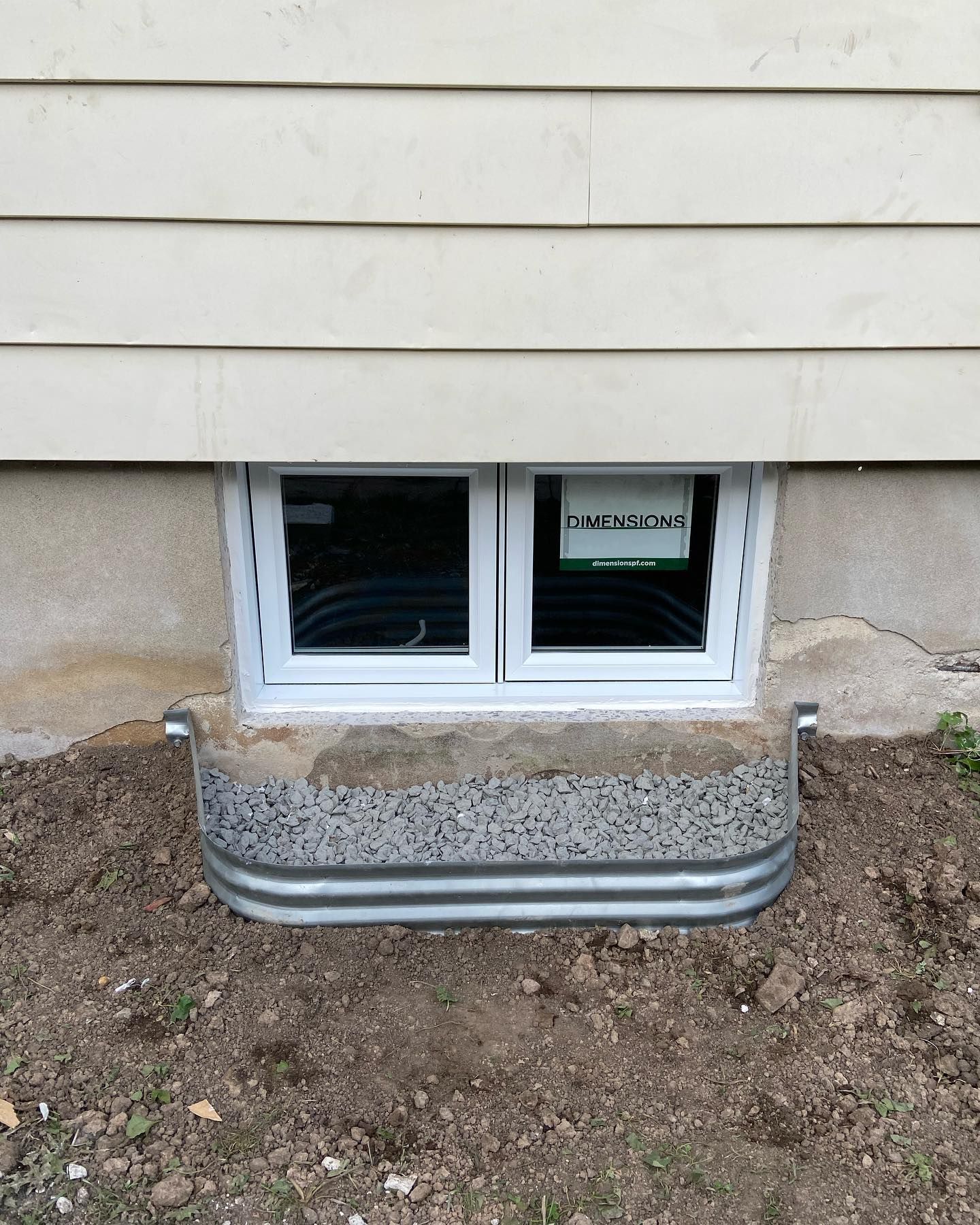 Il y a une fenêtre au sous-sol d'une maison.