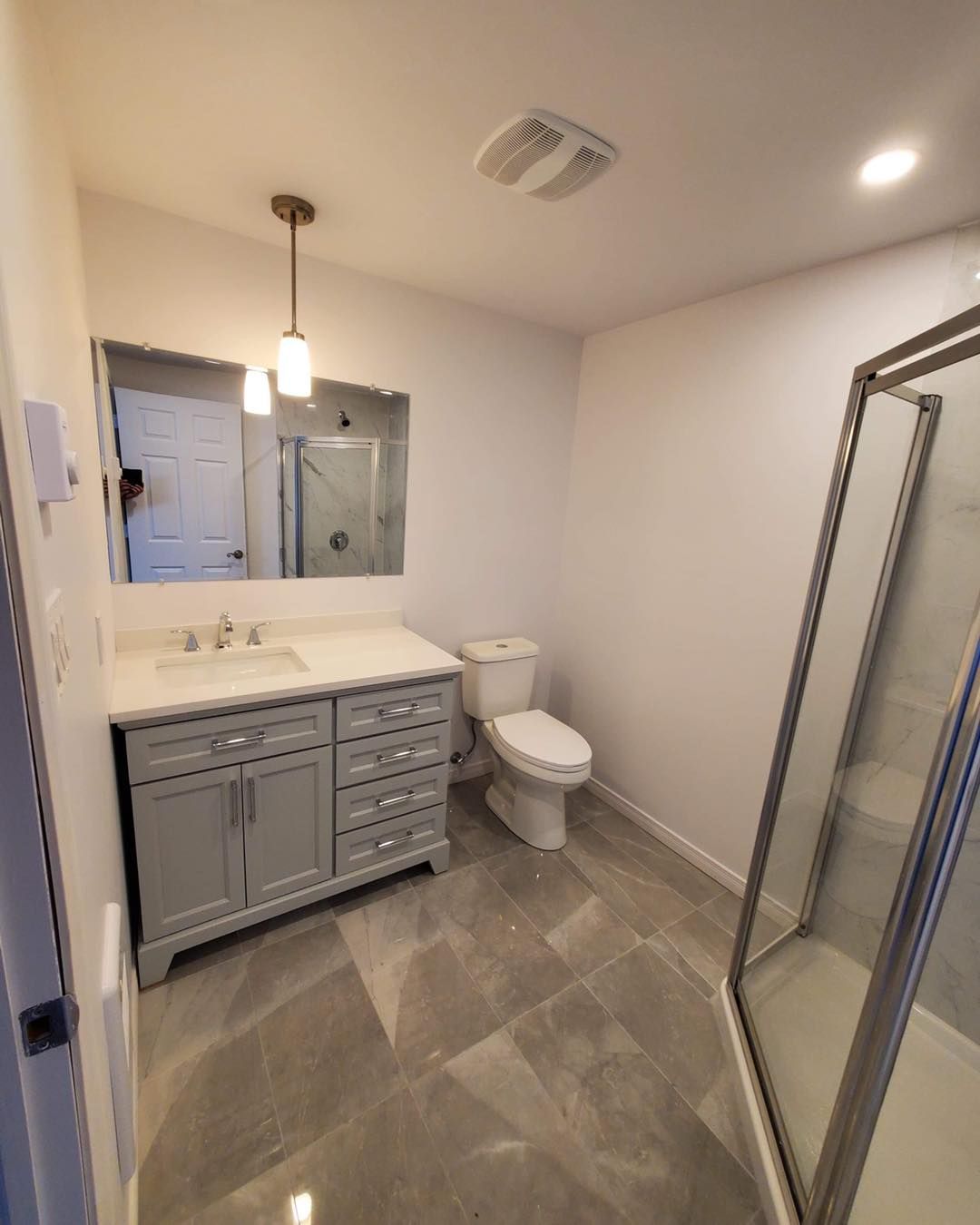 Une salle de bain avec WC, lavabo et douche.