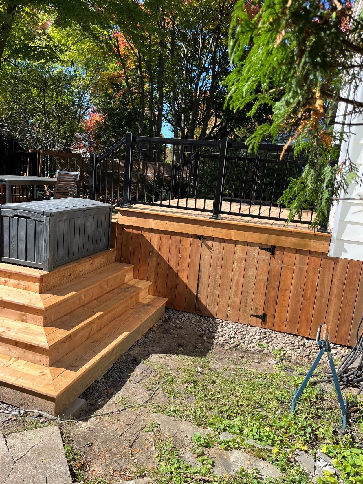Une terrasse en bois avec des escaliers et un bain à remous dans la cour arrière.
