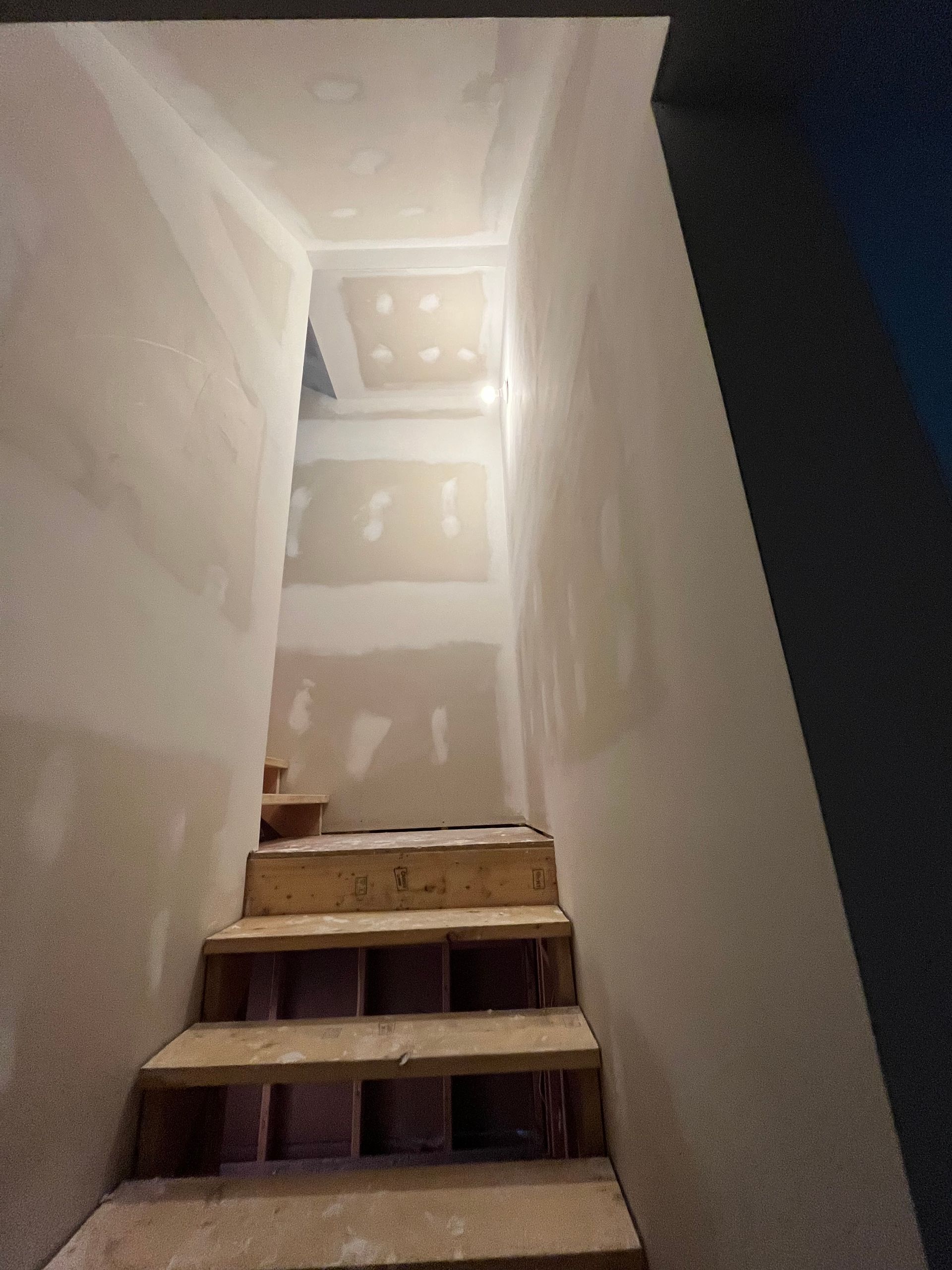 Un ensemble d'escaliers montant un couloir étroit dans un bâtiment.