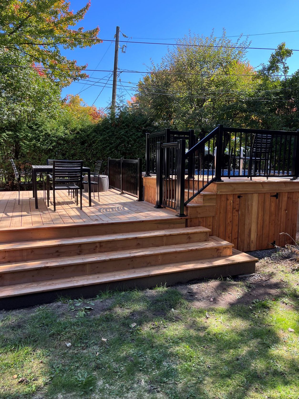 Une terrasse en bois avec des escaliers menant à celle-ci dans une cour arrière.