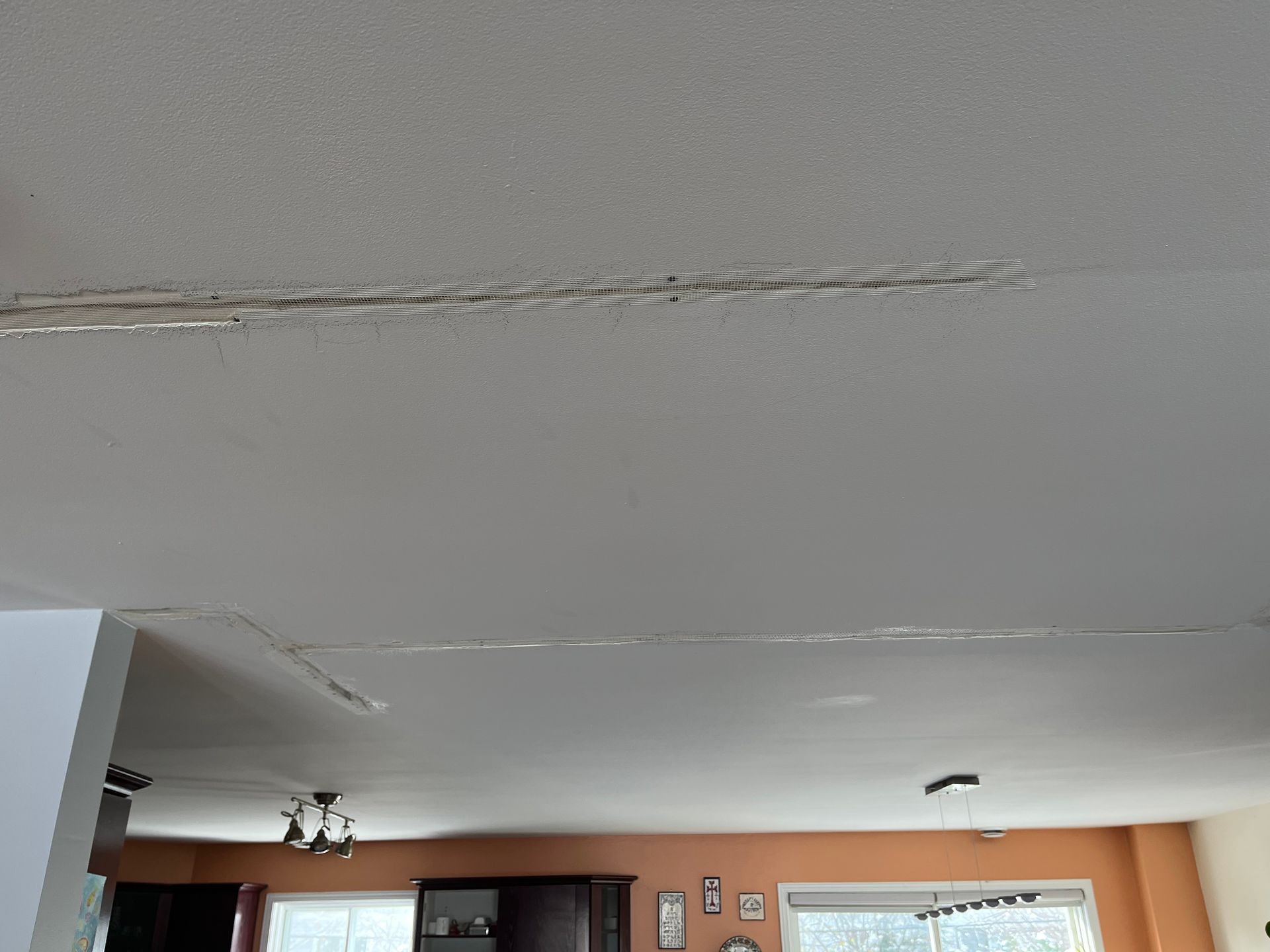 Un salon avec un plafond blanc et des murs orange.