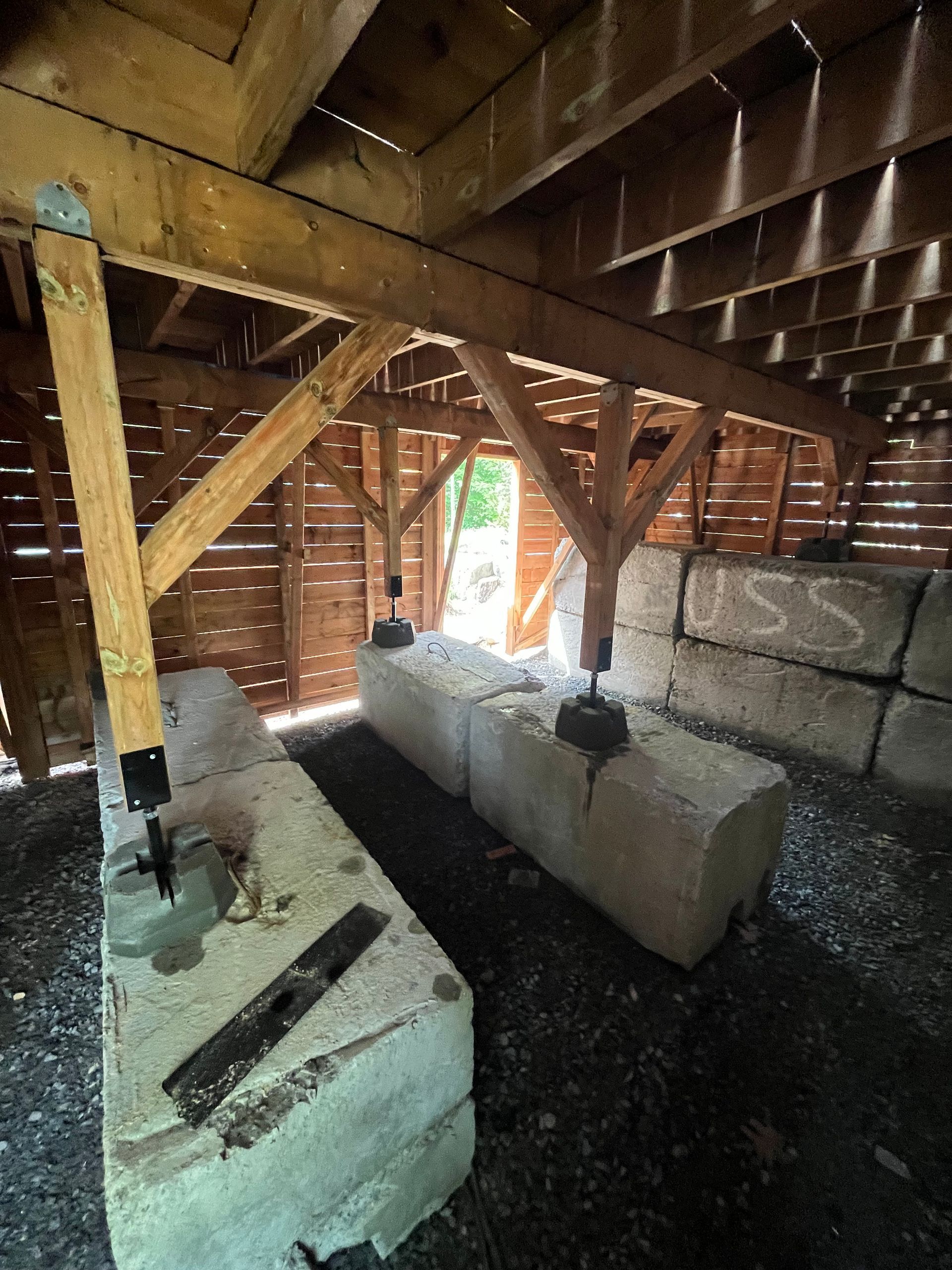 L'intérieur d'une grange avec des blocs de béton et des poutres en bois.