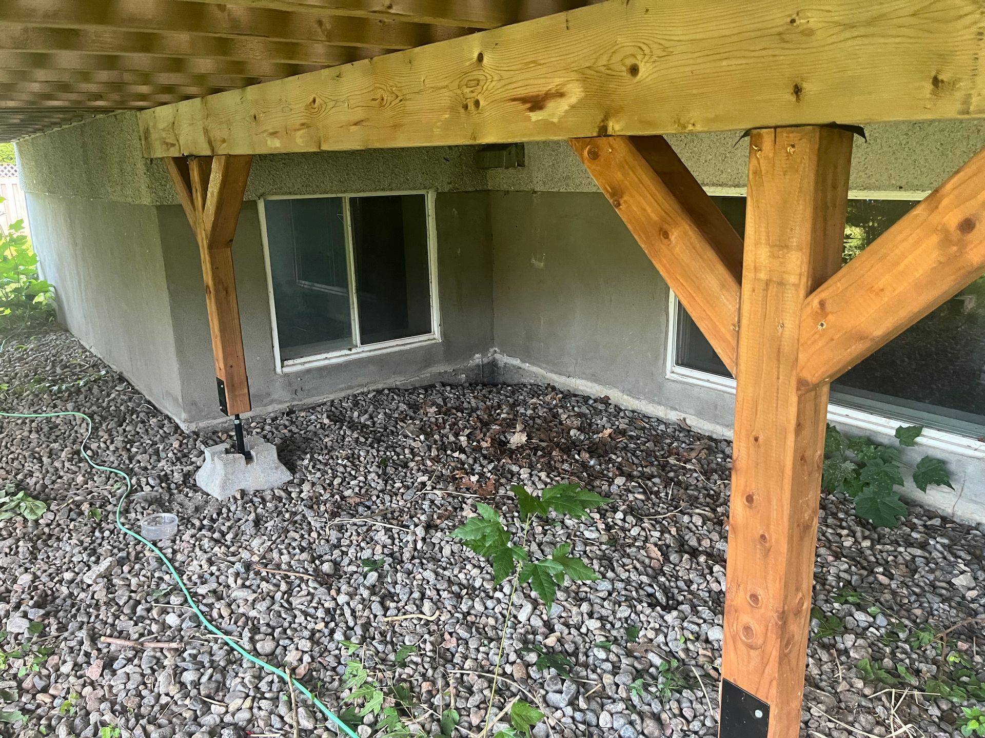 Une structure en bois se trouve sous une maison.