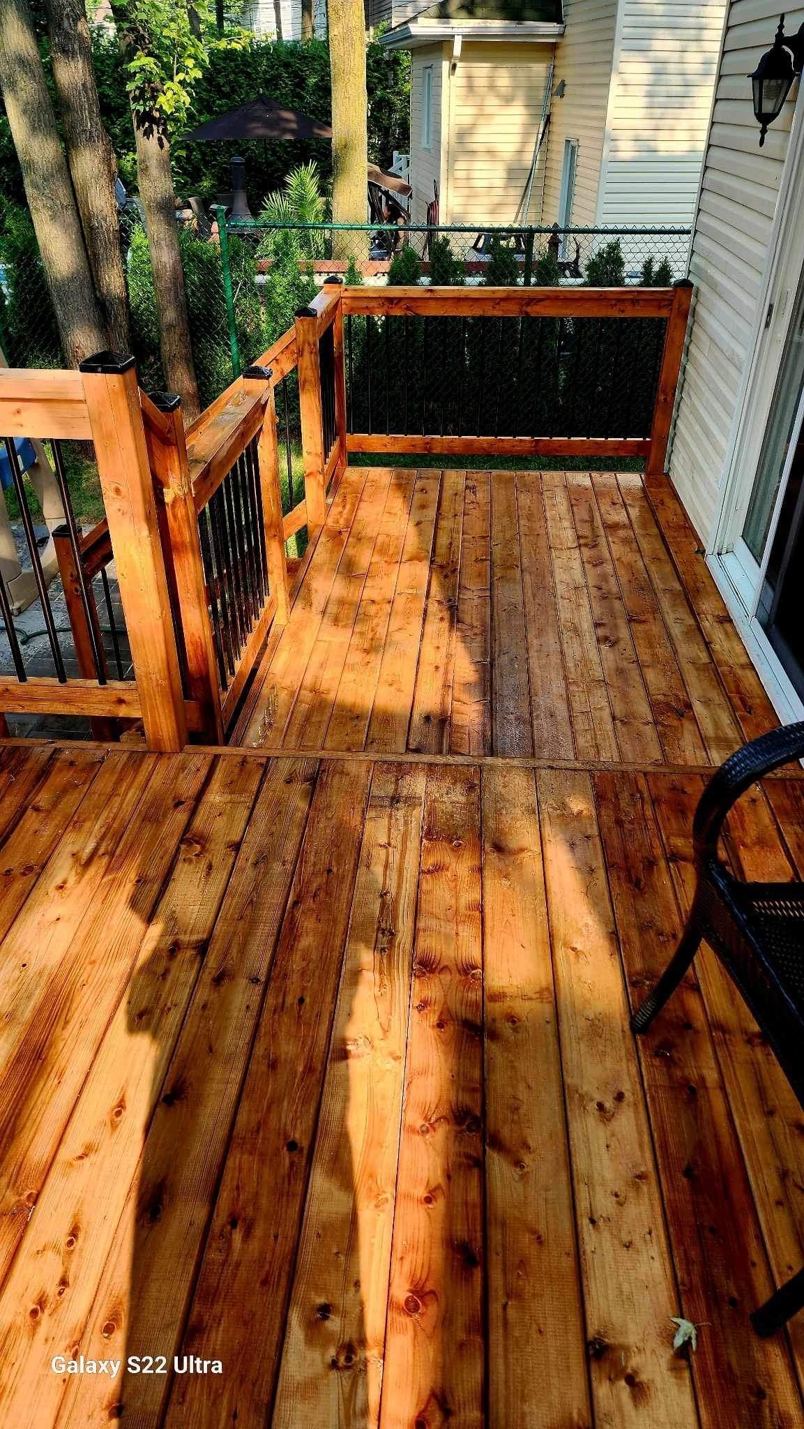Une terrasse en bois avec des escaliers et une chaise dessus.
