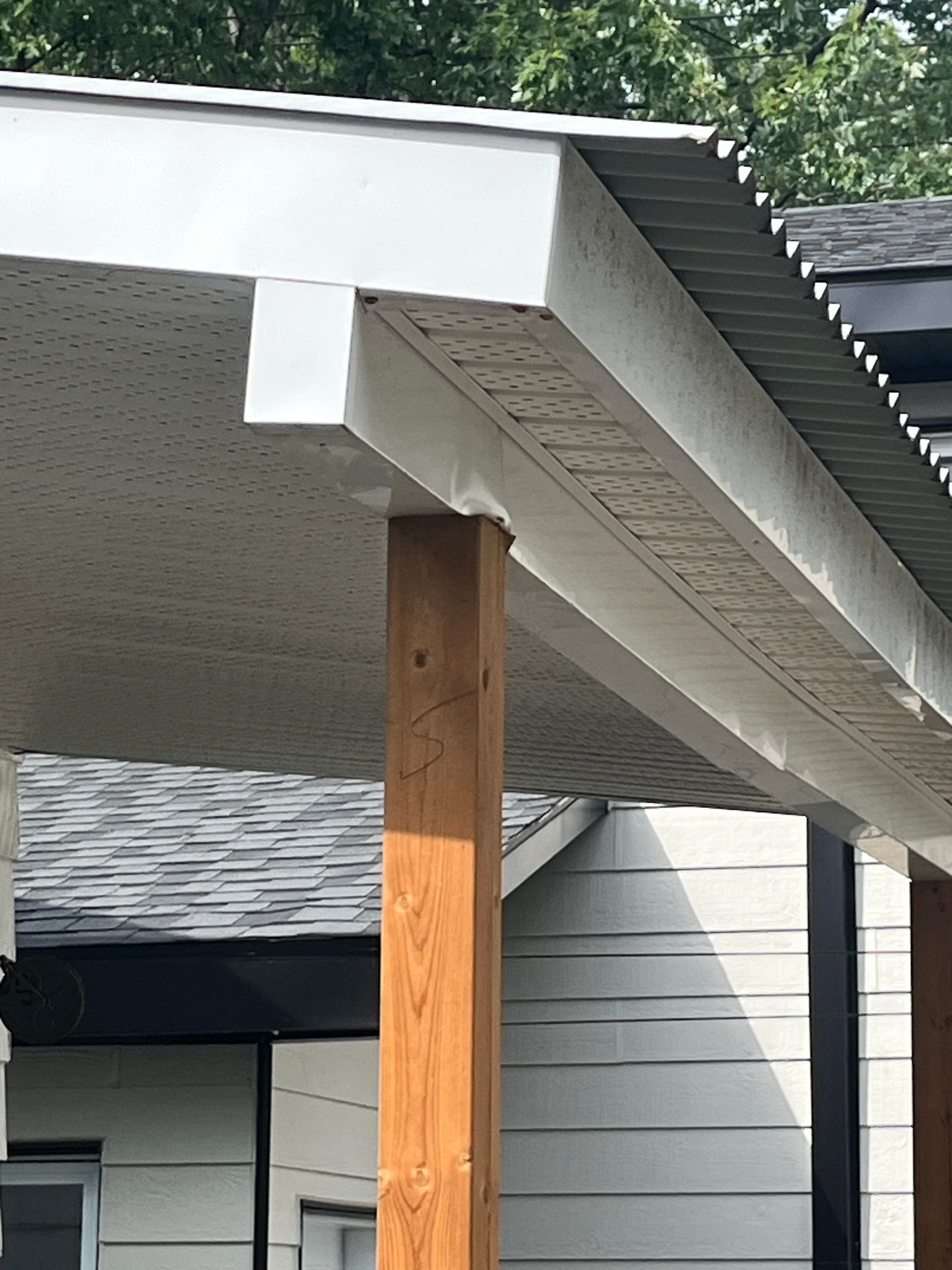 Le toit d'une maison avec un poteau en bois en dessous.