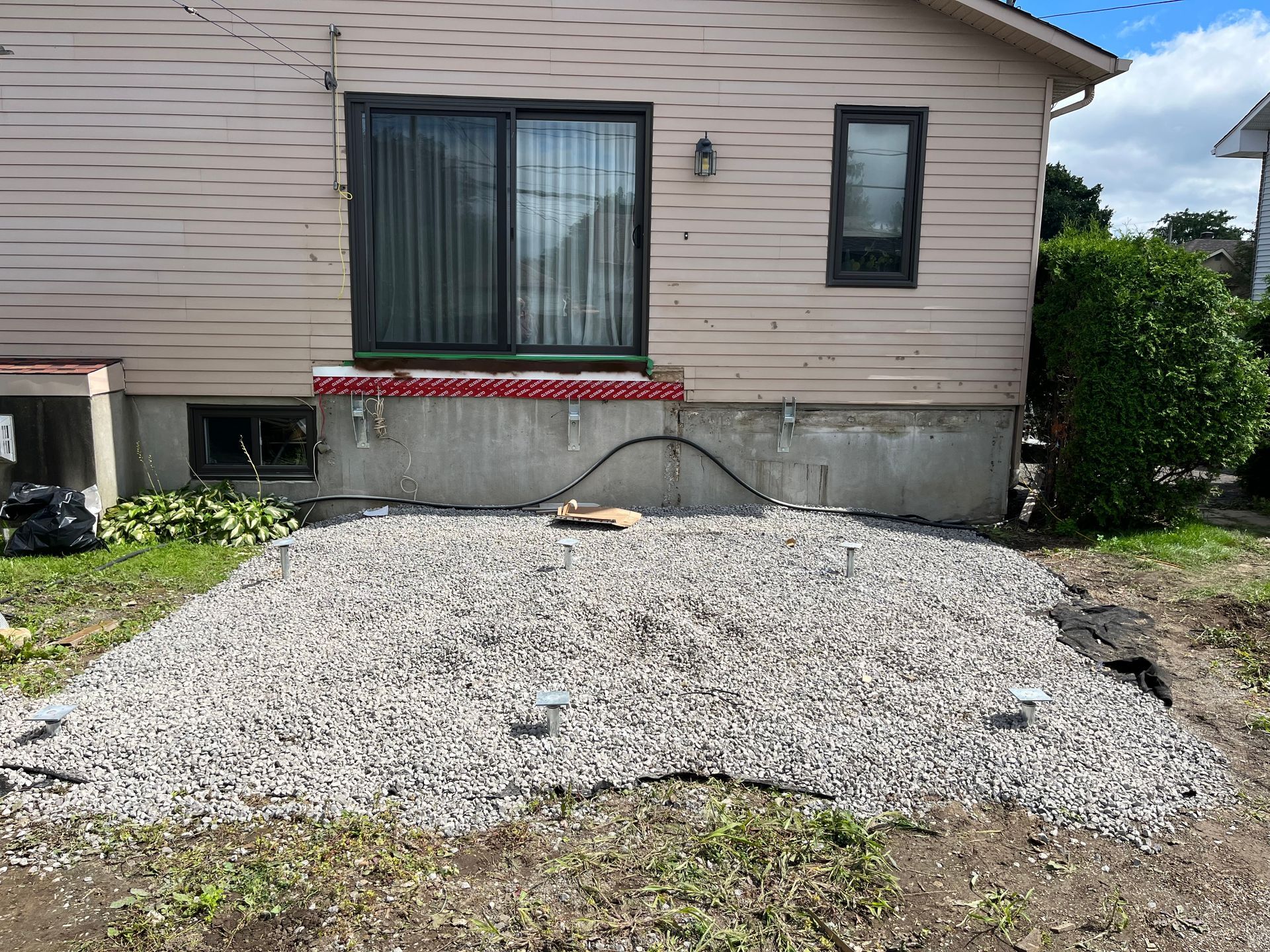 Une maison avec une zone de gravier devant elle.