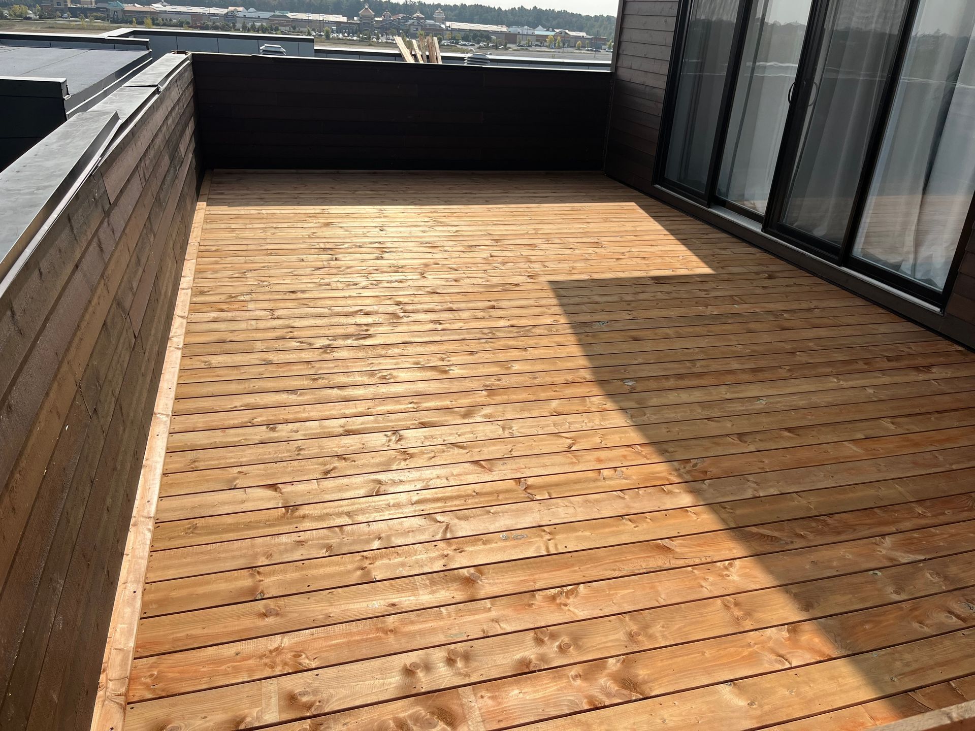 Une terrasse en bois sur le toit d'un immeuble.