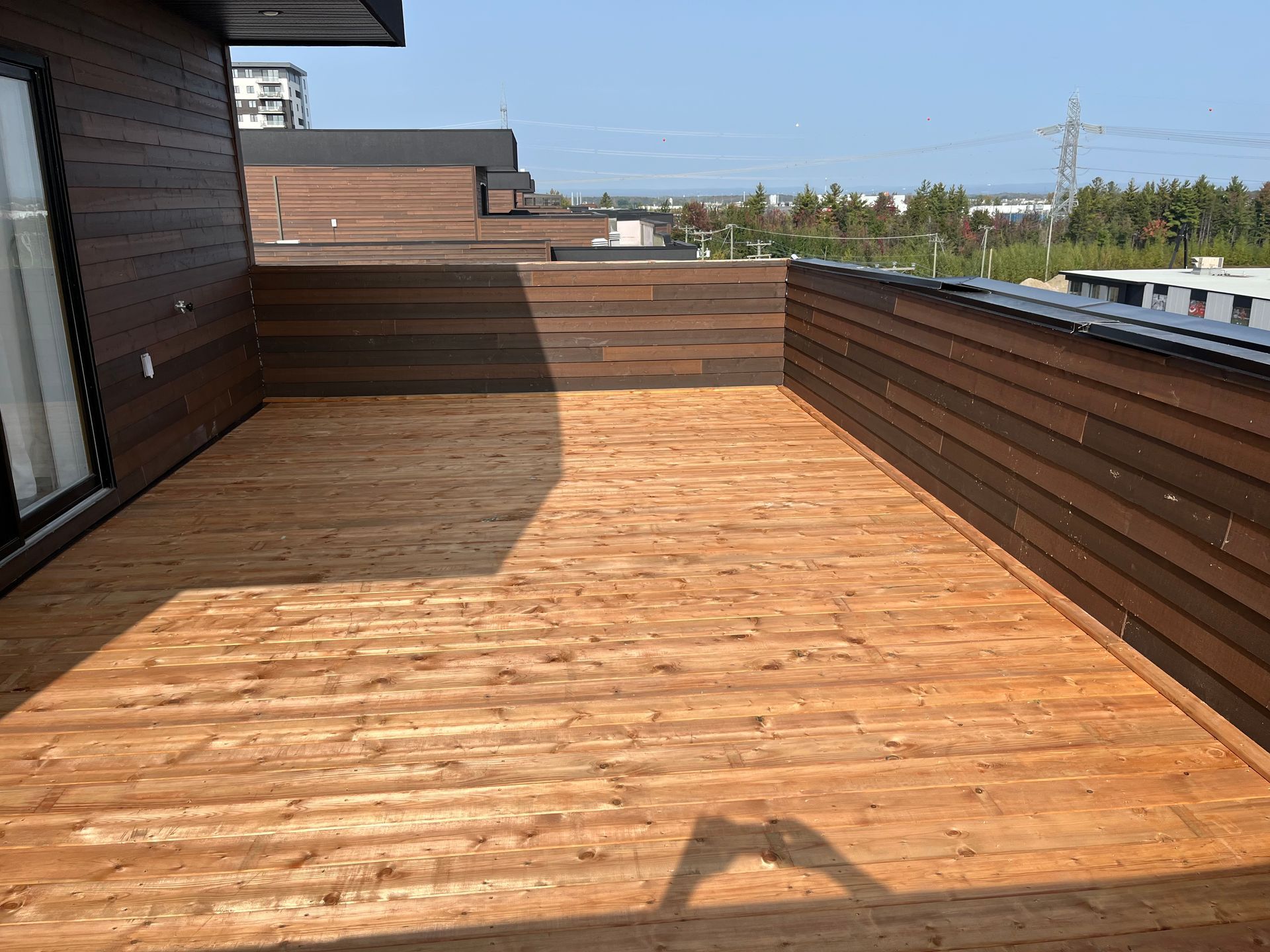 Il y a une terrasse en bois sur le toit d'un immeuble.
