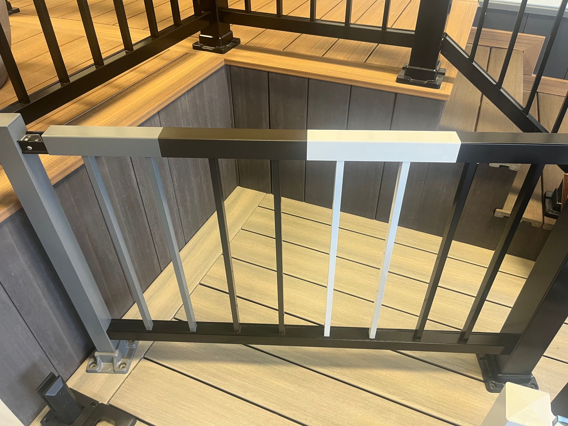Une balustrade noire et blanche est posée sur une terrasse en bois.