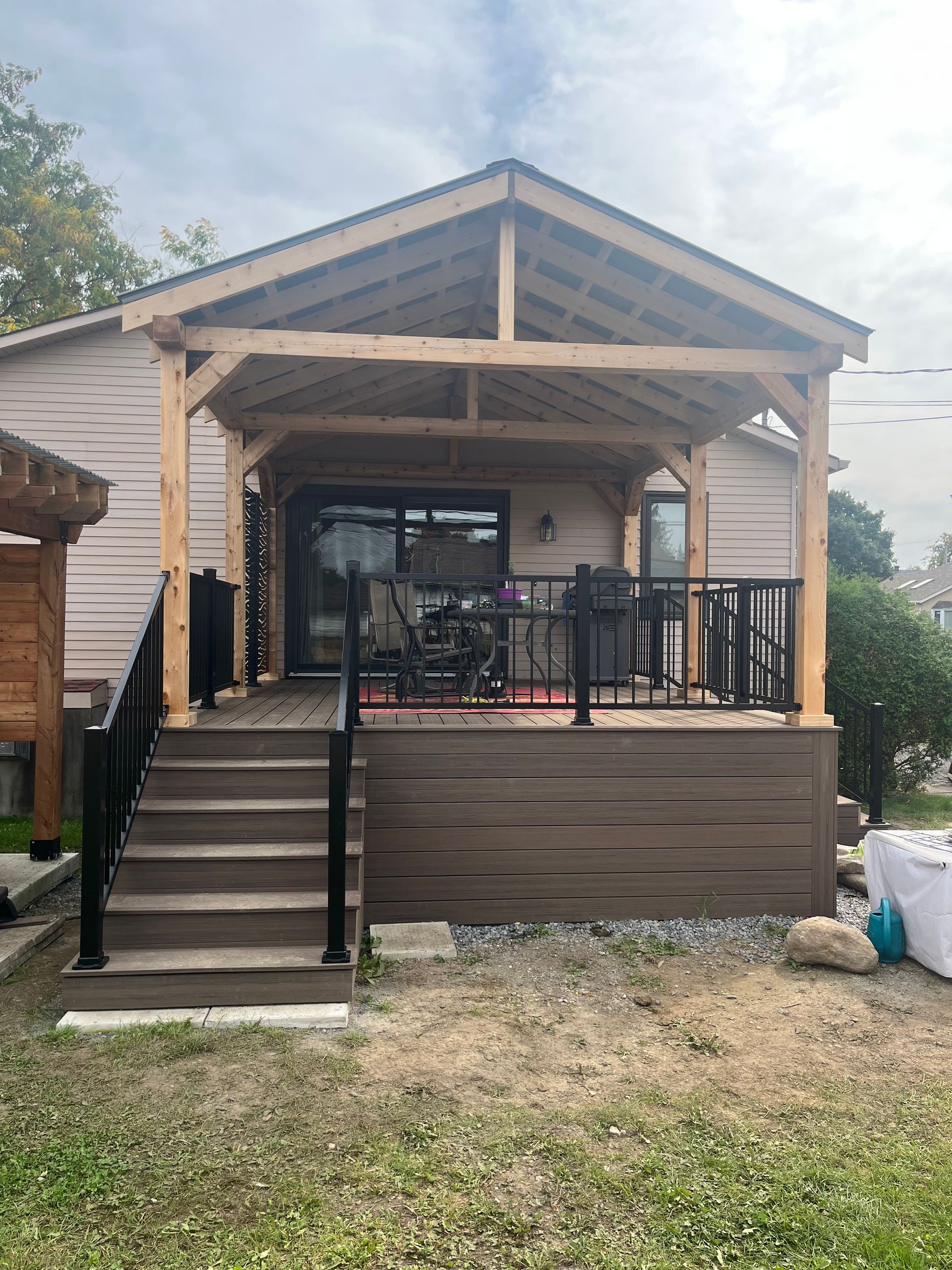 Une maison avec une terrasse et des escaliers devant.