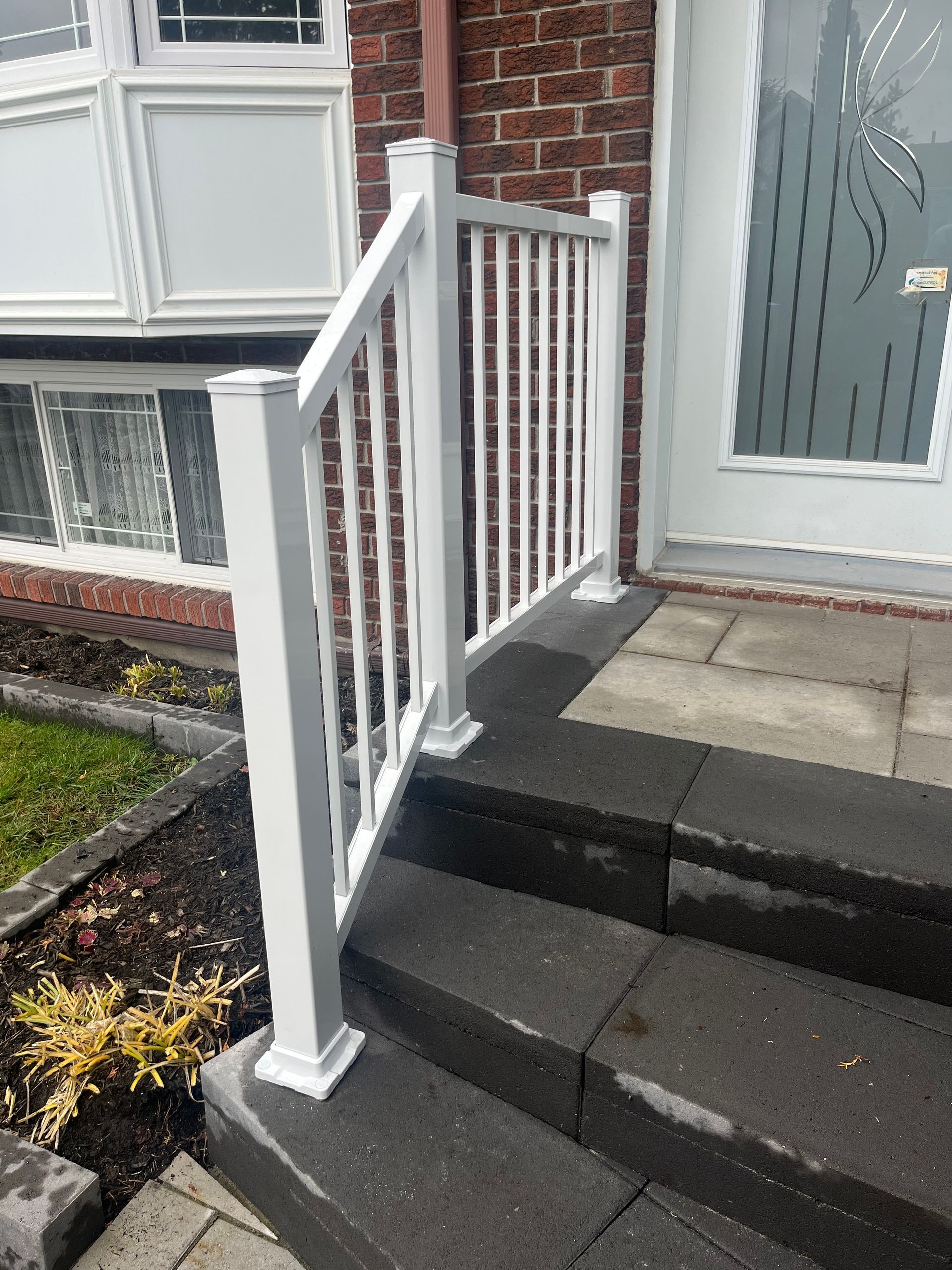 Il y a une balustrade blanche sur les marches d'une maison.