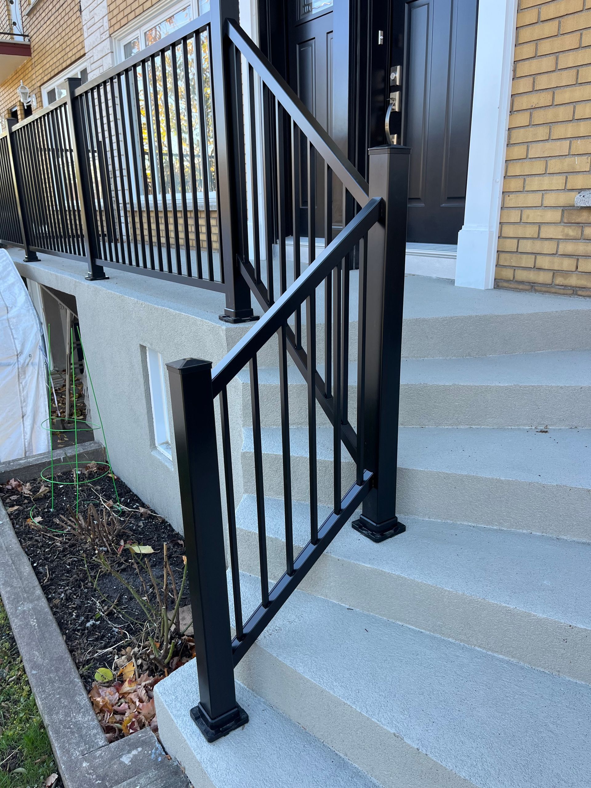 Une rampe noire se trouve sur les escaliers d'une maison.