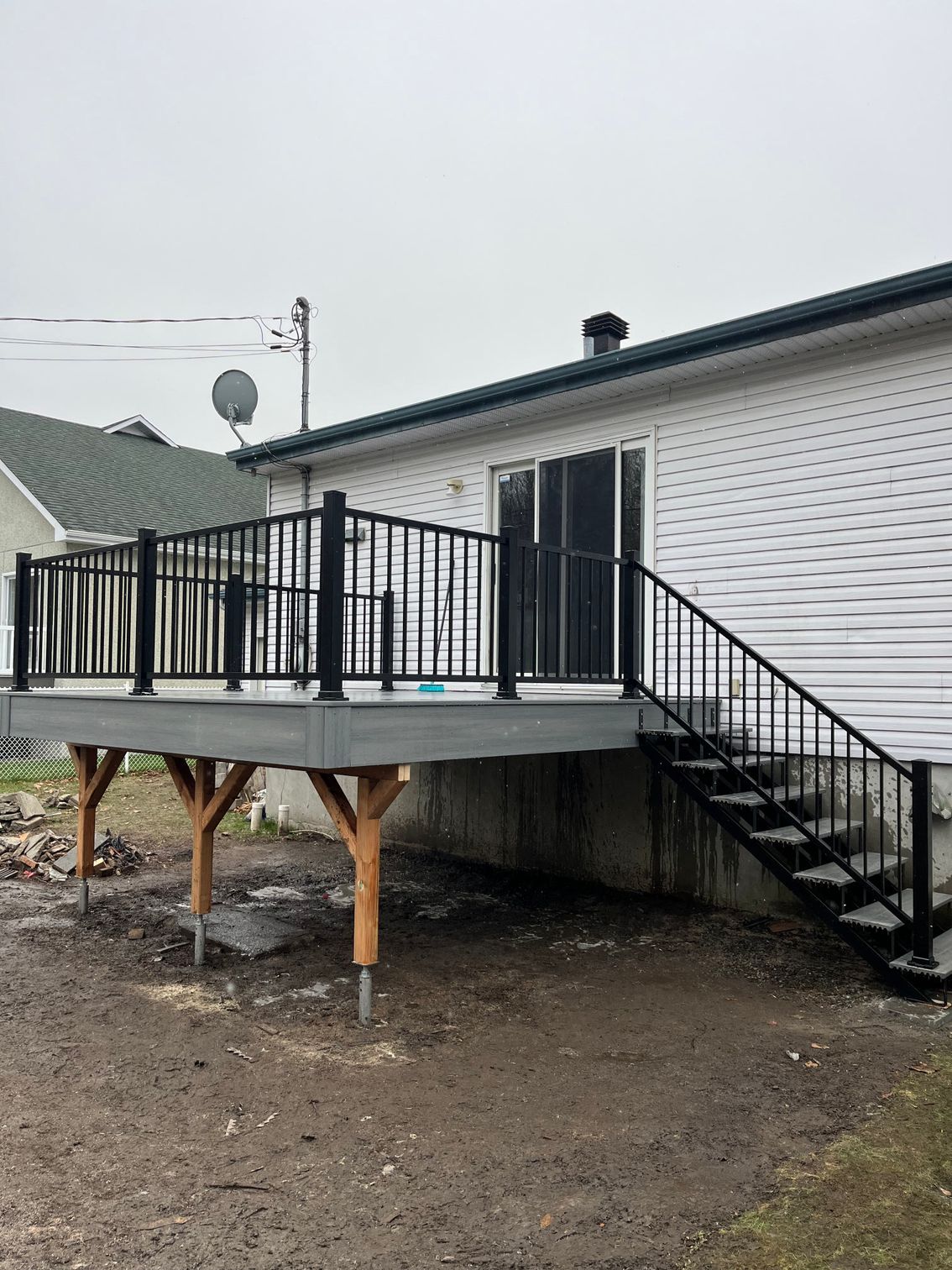 Une terrasse avec des escaliers qui y mènent se trouve devant une maison.