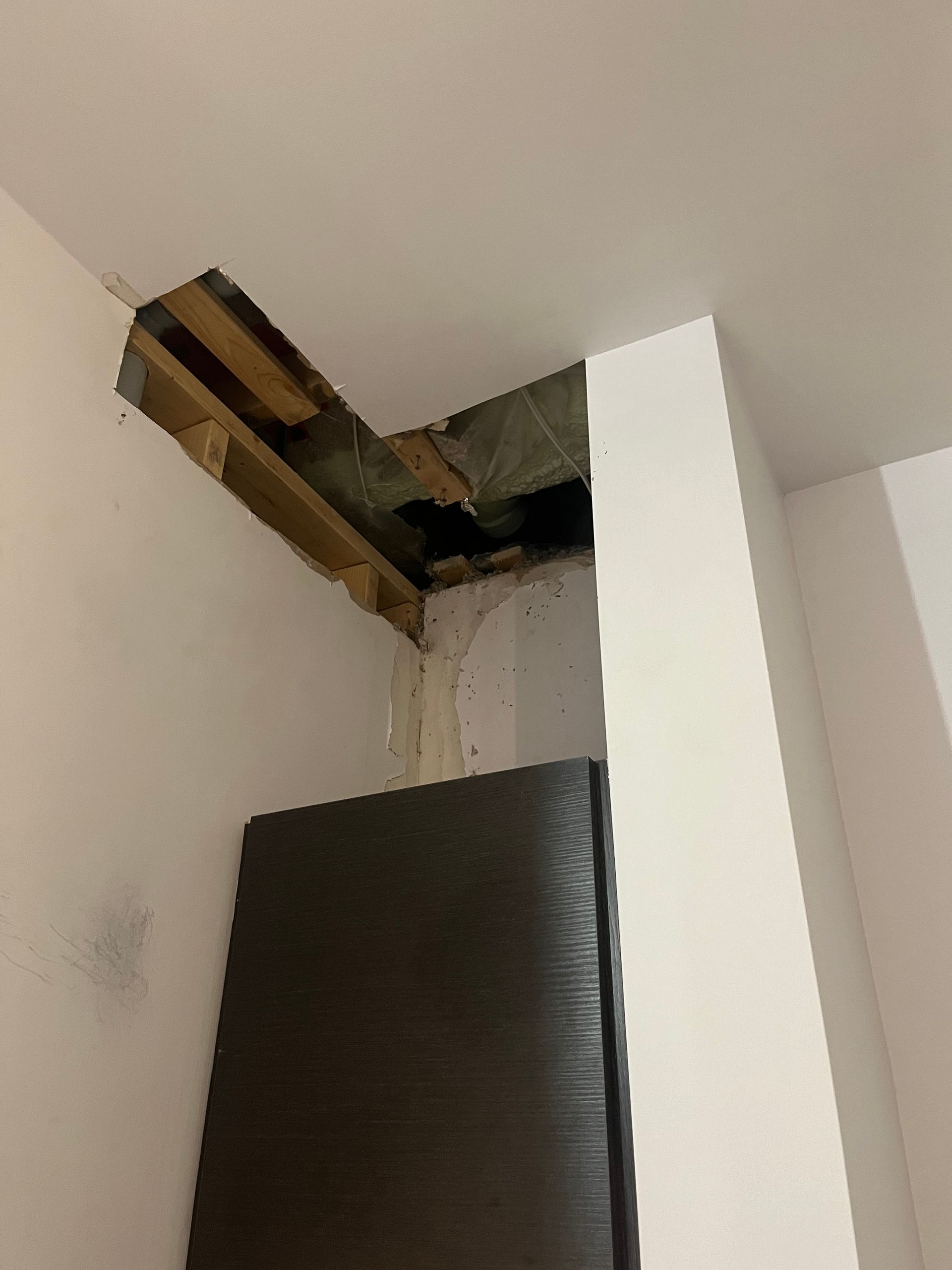 Une pièce avec un trou dans le plafond et un matelas sur le sol.