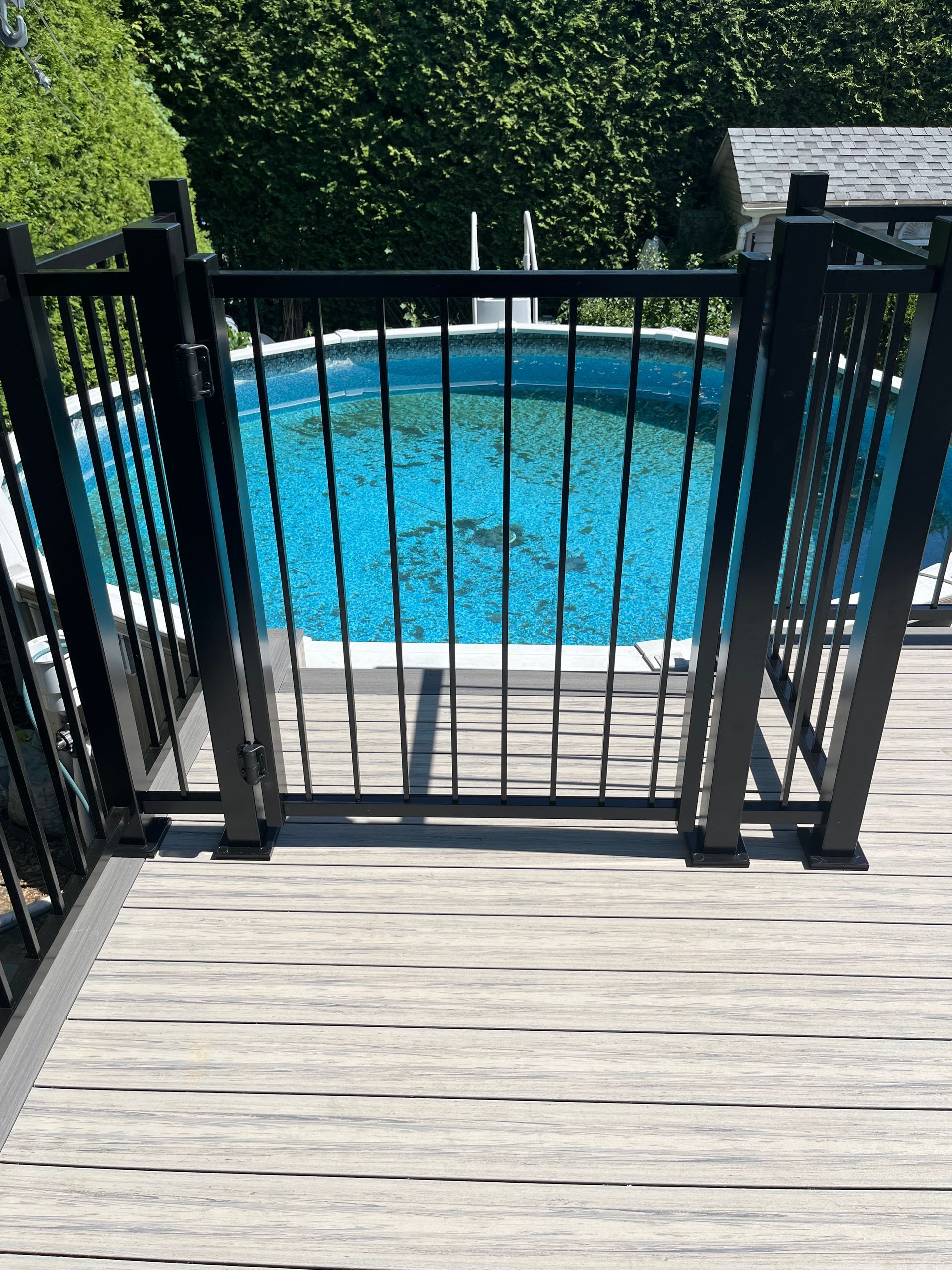 Une piscine est derrière une clôture sur une terrasse.