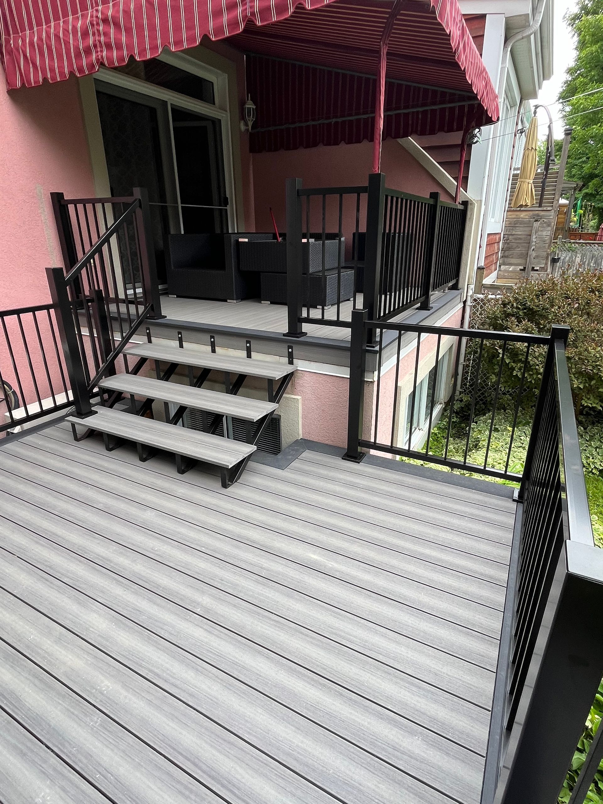 Une terrasse avec des escaliers et un auvent au-dessus.