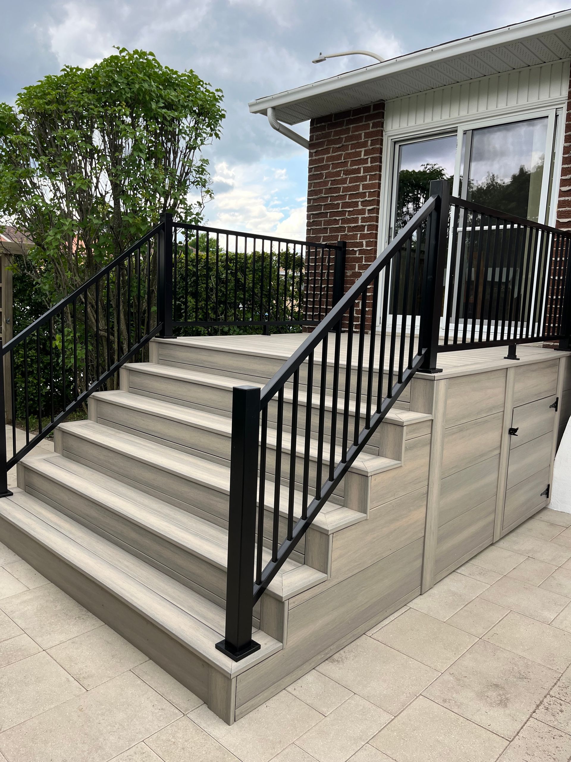 Un escalier menant à une maison avec une rampe noire