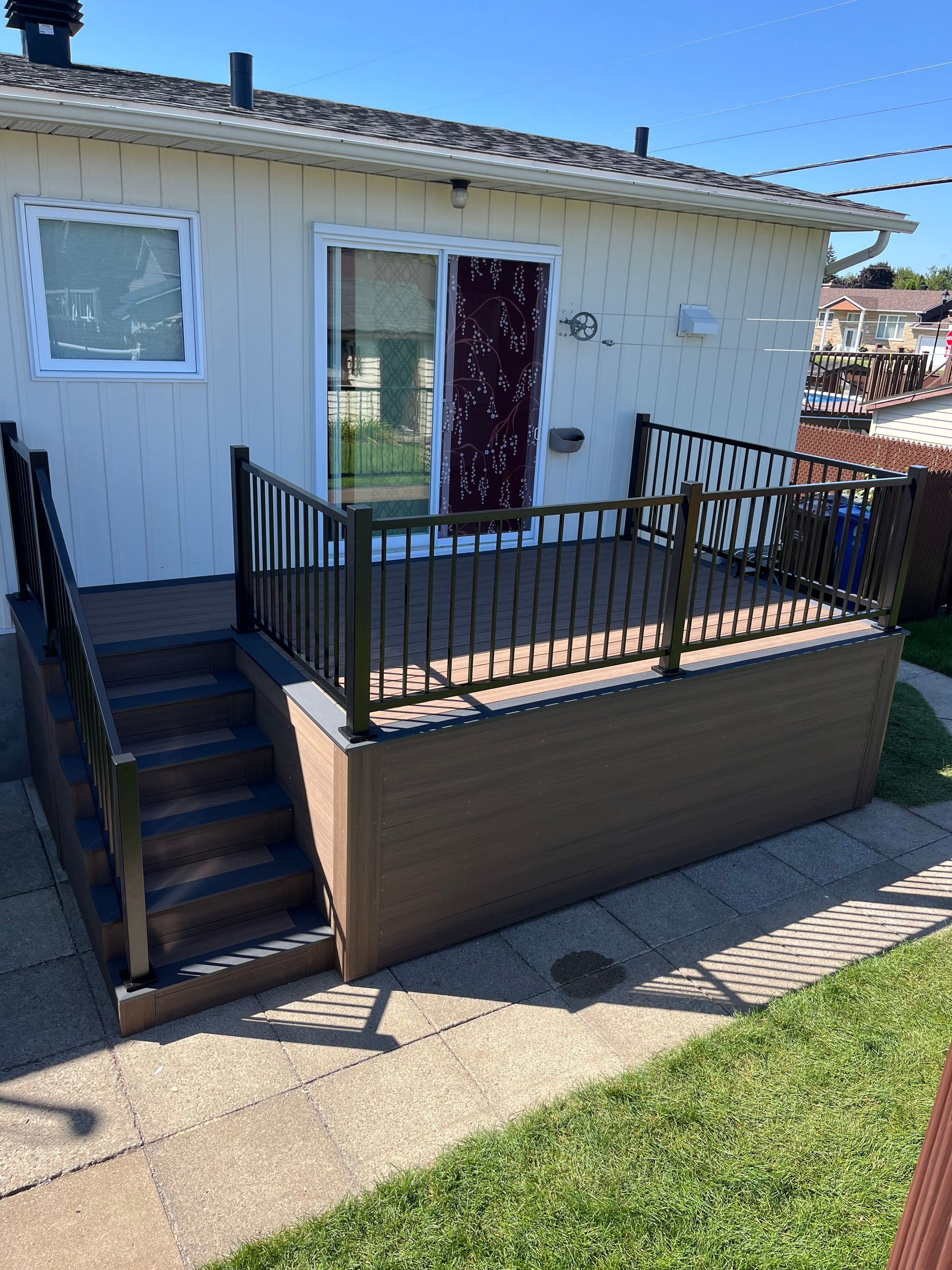Une maison avec une terrasse et des escaliers devant