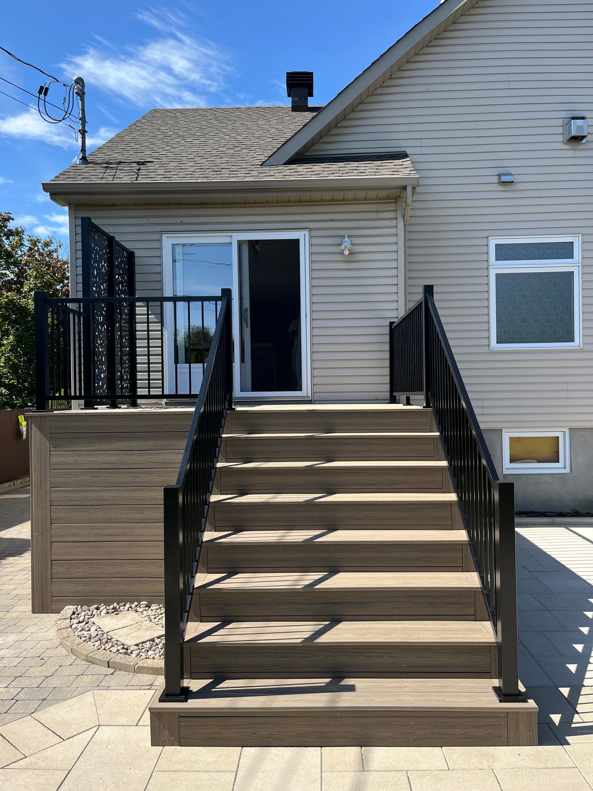 Une maison avec une terrasse et des escaliers qui y mènent