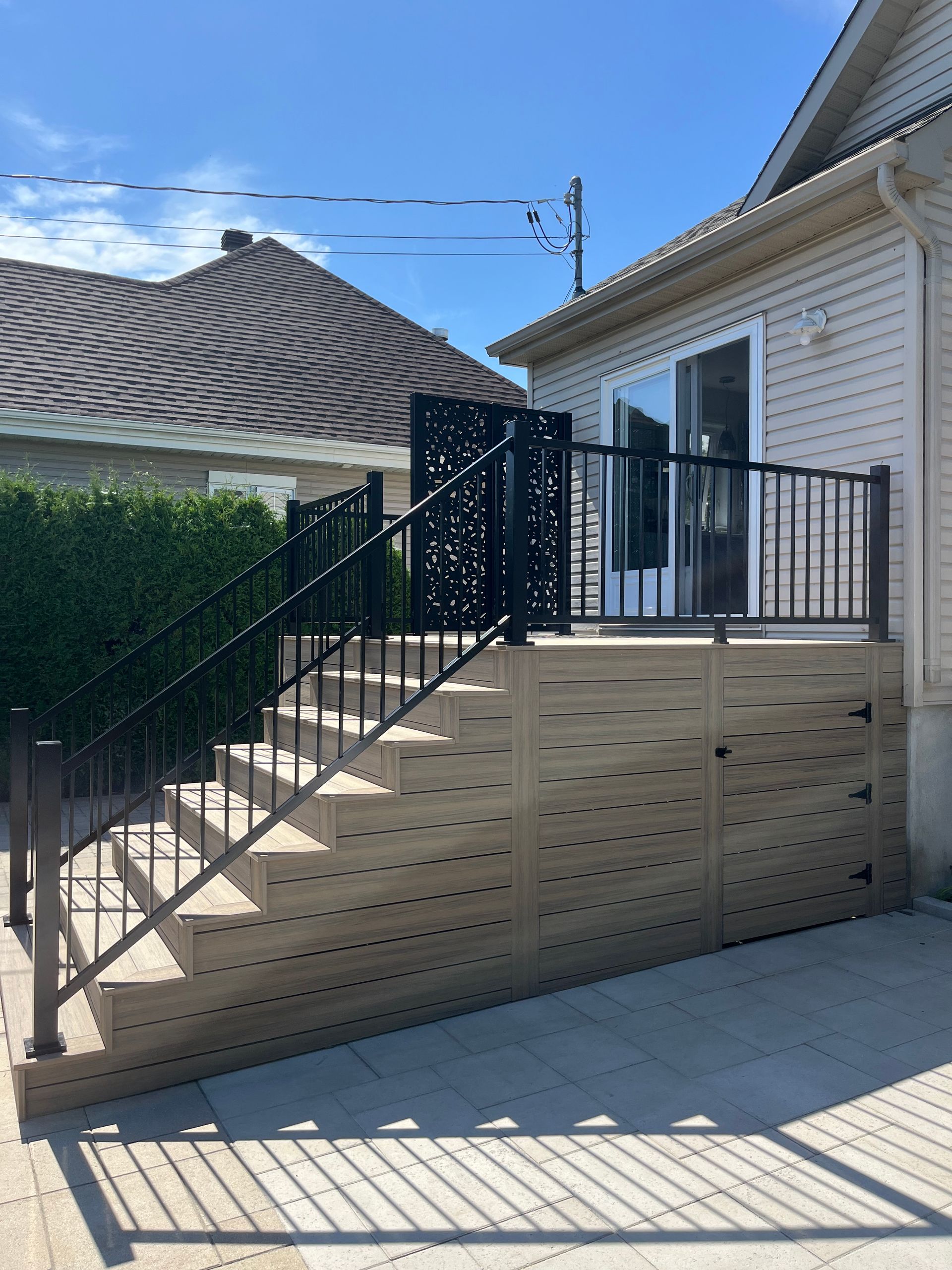 Une maison blanche avec une balustrade et des escaliers noirs