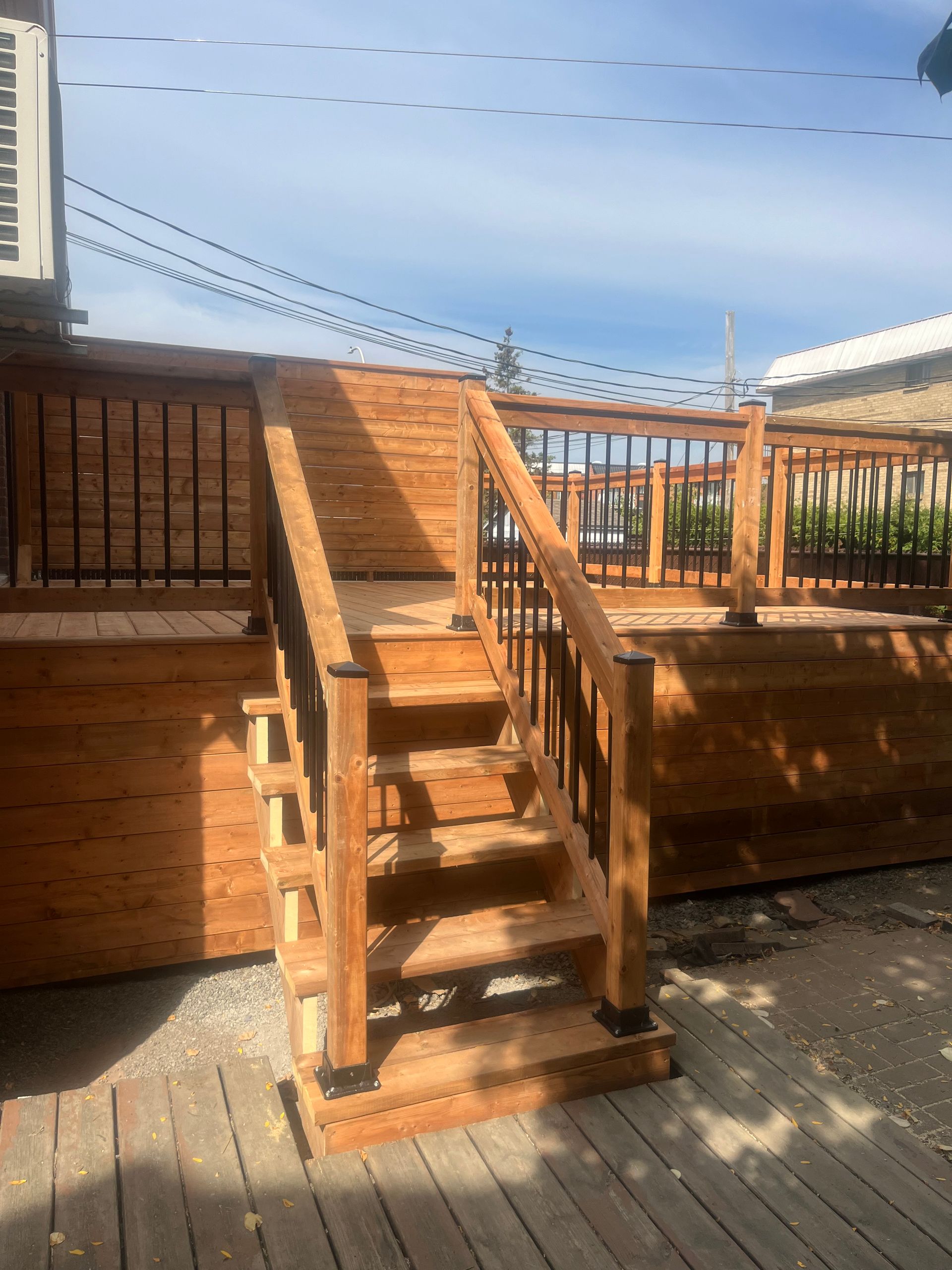 Une terrasse en bois avec des escaliers qui y mènent.