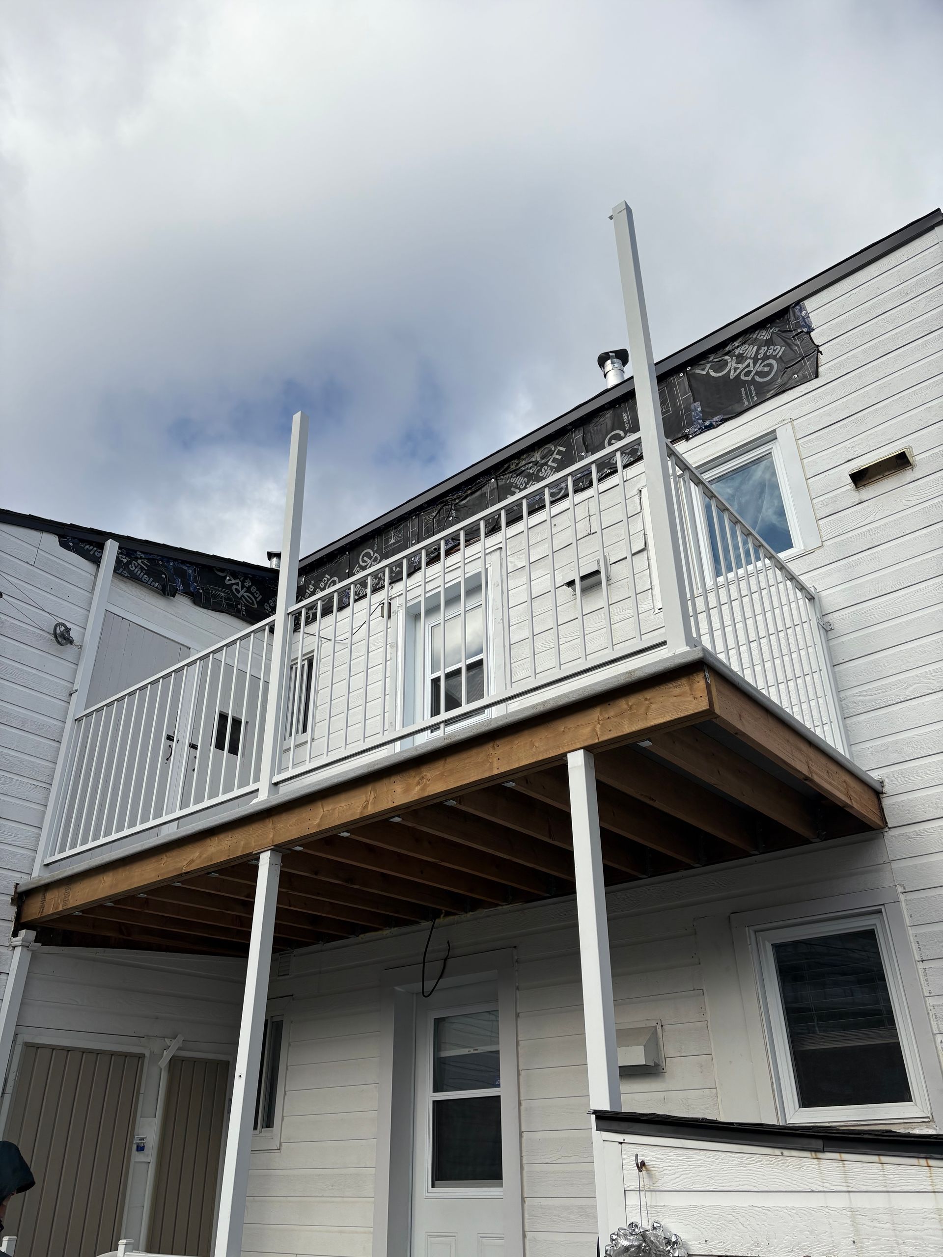 Une maison blanche avec un balcon sur le côté.