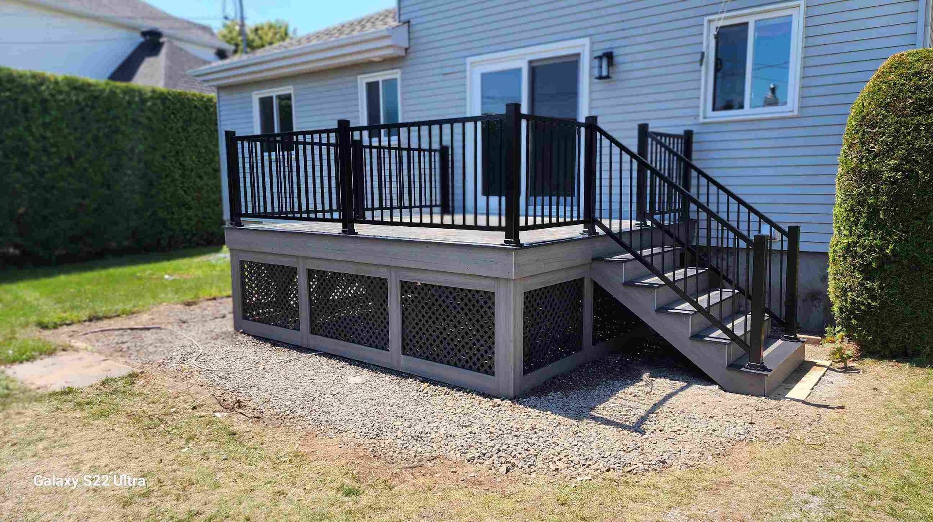 Une terrasse avec des escaliers qui y mènent se trouve devant une maison.