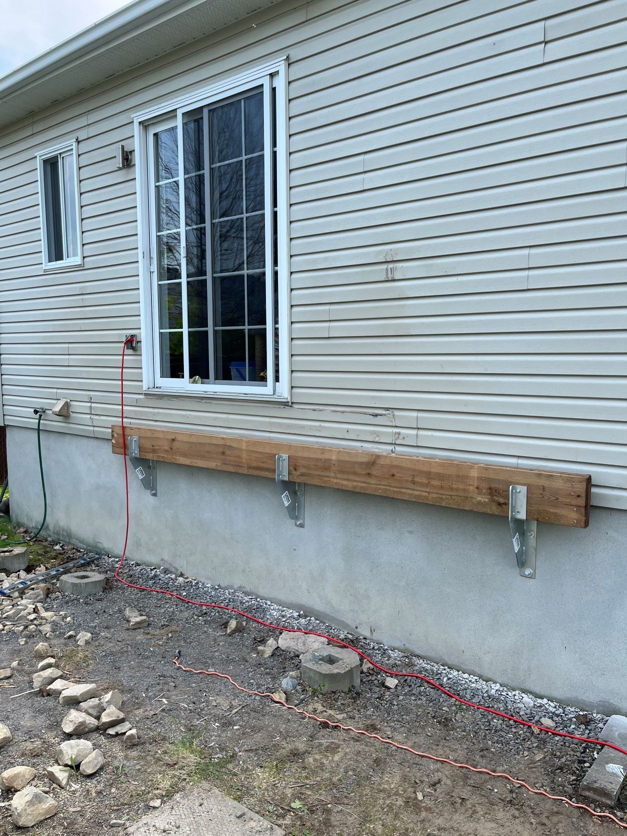 Une maison avec une poutre en bois attachée sur le côté.