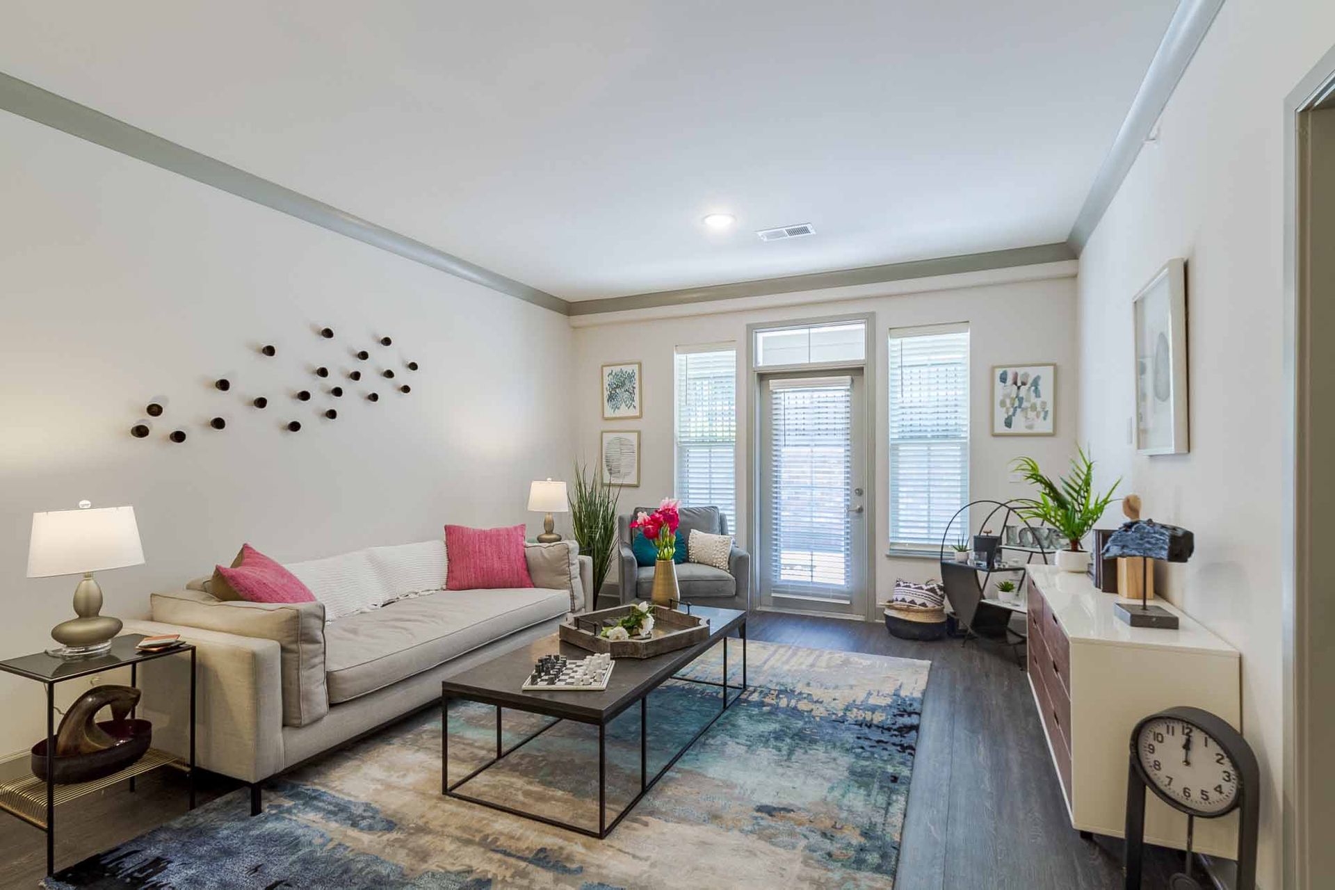 Living room with gray sofa, coffee table, rug, and balcony door.