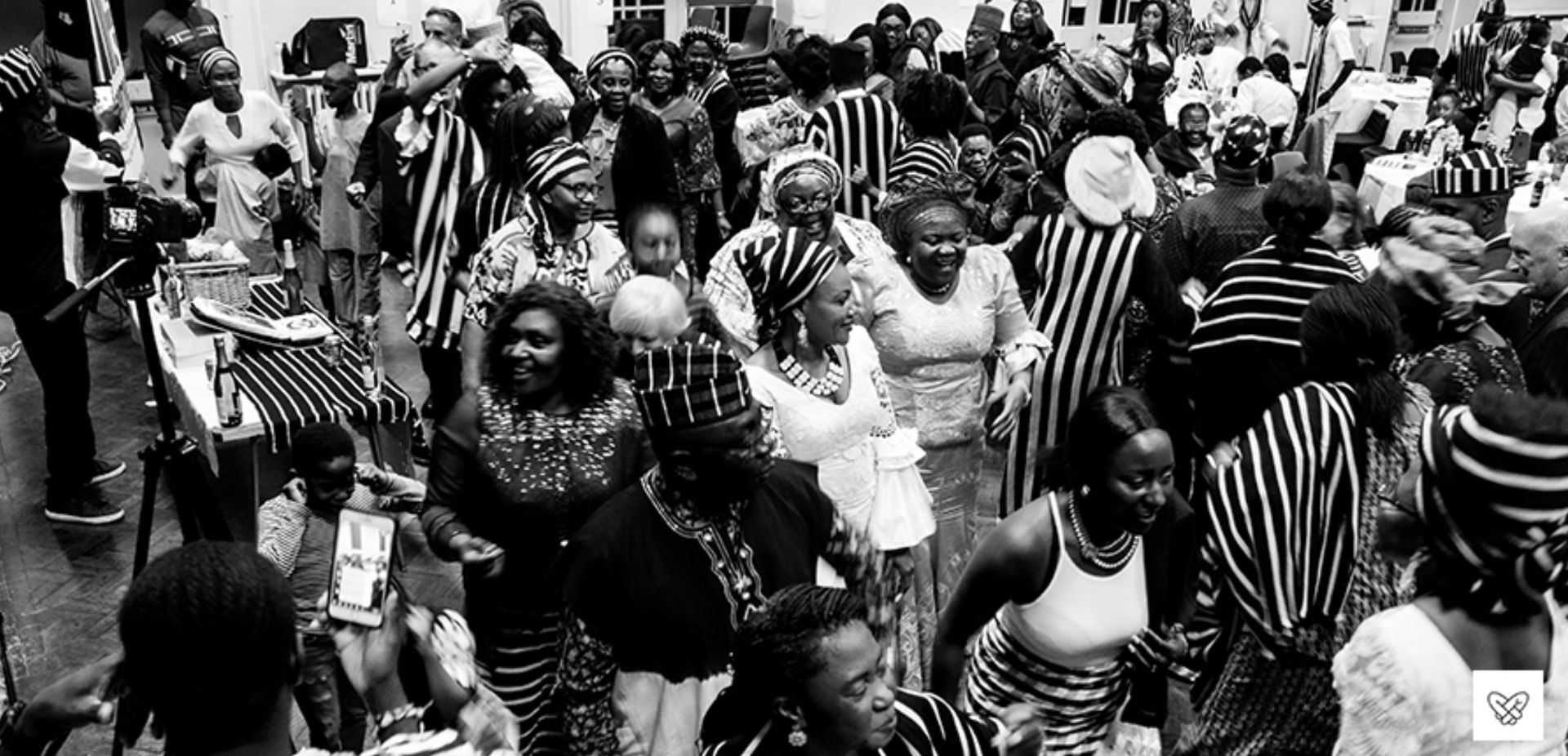 A large group of people are dancing in a black and white photo.