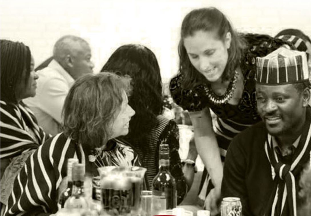 A group of people are sitting at a table talking to each other.