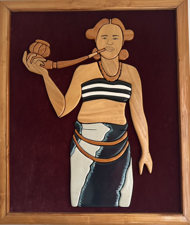 Tiv carving of woman smoking a long pipe draped in white and black striped fabric