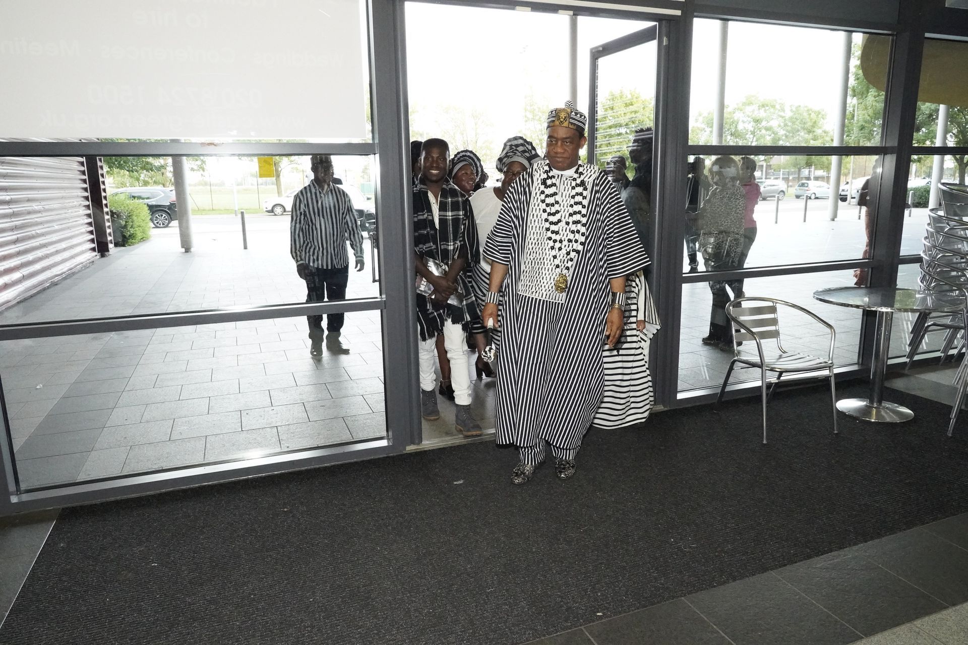 A group of people standing in front of a glass door