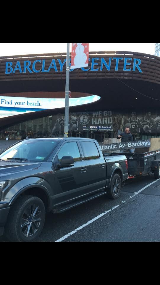 Dark pickup truck towing a trailer in front of Barclays Center, Brooklyn, NY.