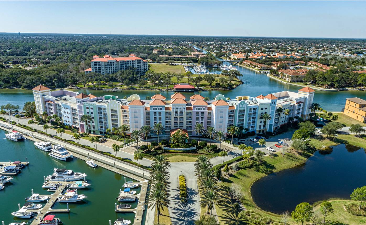An aerial view of a large building next to a body of water.
