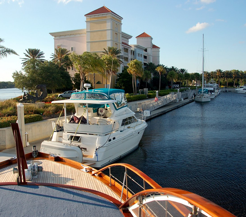 A boat is docked in a marina with a building in the background