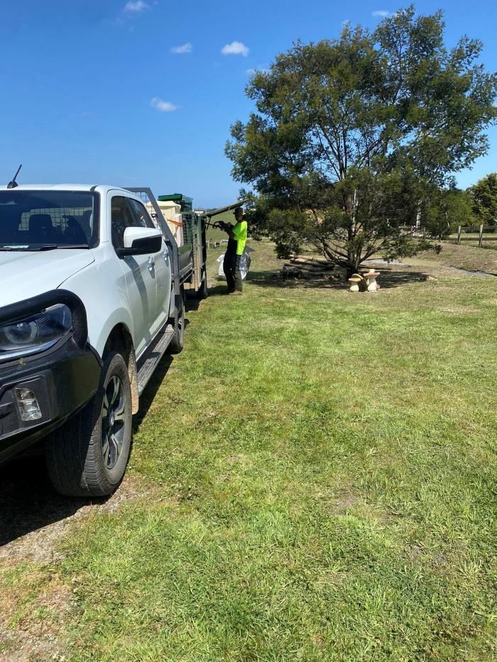 A White Truck Is Parked in A Grassy Field Next to A Tree — Hayman Acres Garden Services In Undera, VIC 