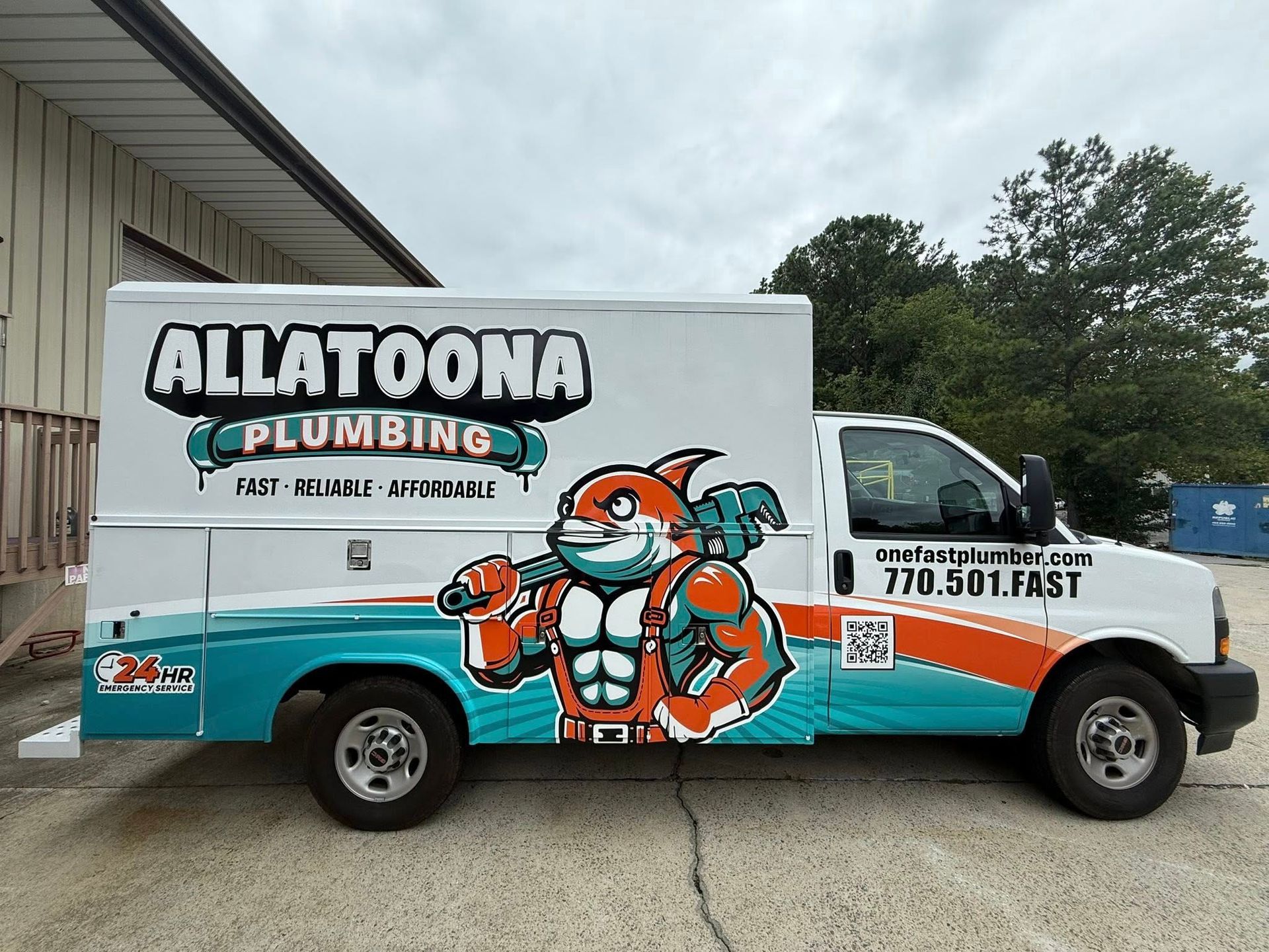 Allatoona Plumbing truck with cartoon shark mascot. Turquoise and orange graphics.