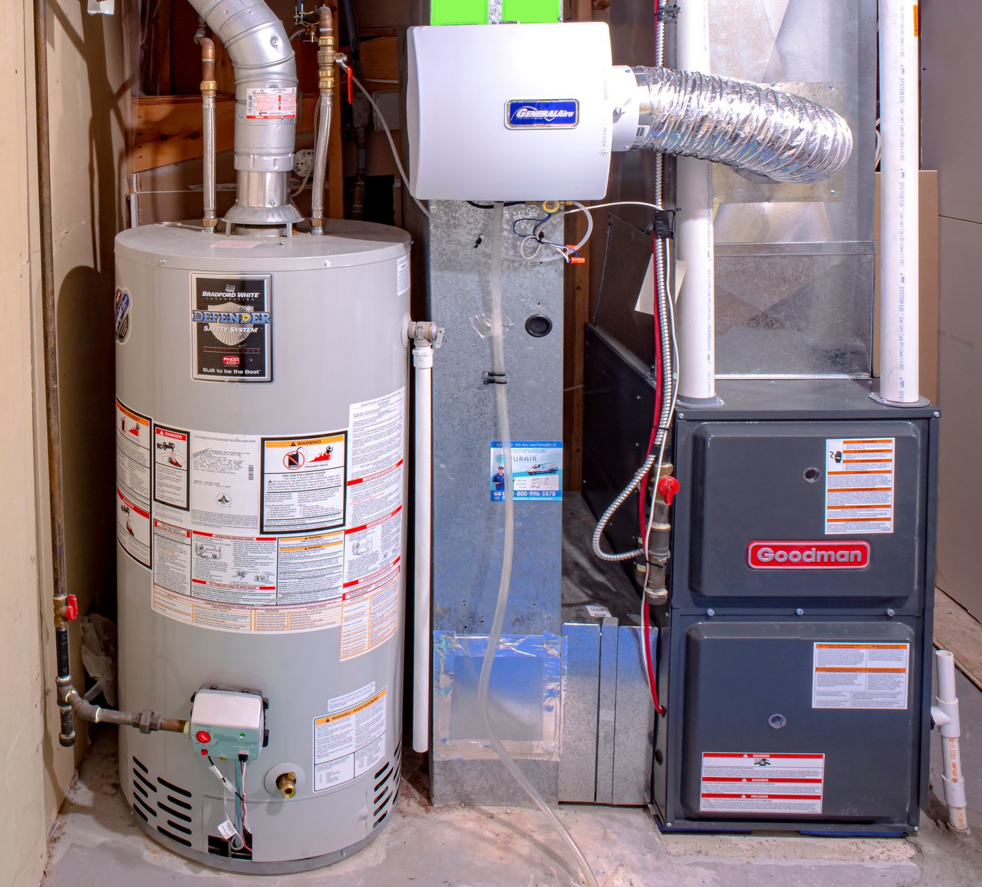 Water heater, furnace, and humidifier in a basement setting; gray and white appliances.
